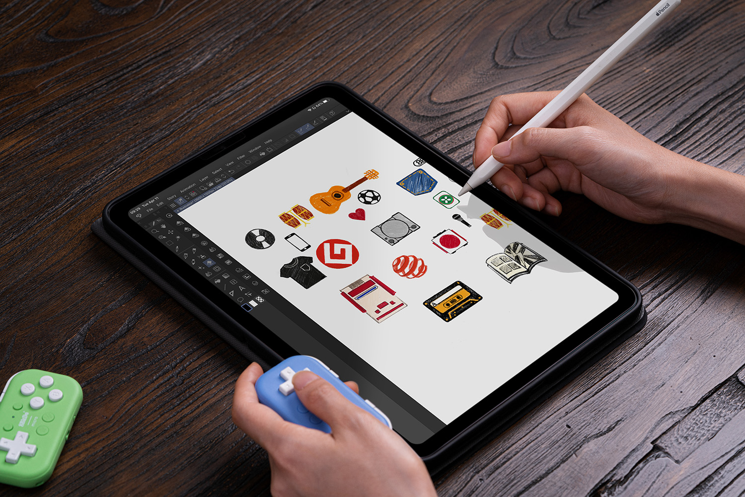 Eine Hand benutzt einen Stift auf einem Tablet mit verschiedenen Symbolen und zwei Gamecontrollern.