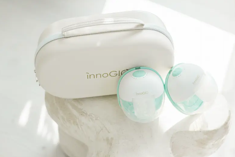 Biała torba i dwie laktatory z miętowo-zielonymi akcentami na kamieniu.