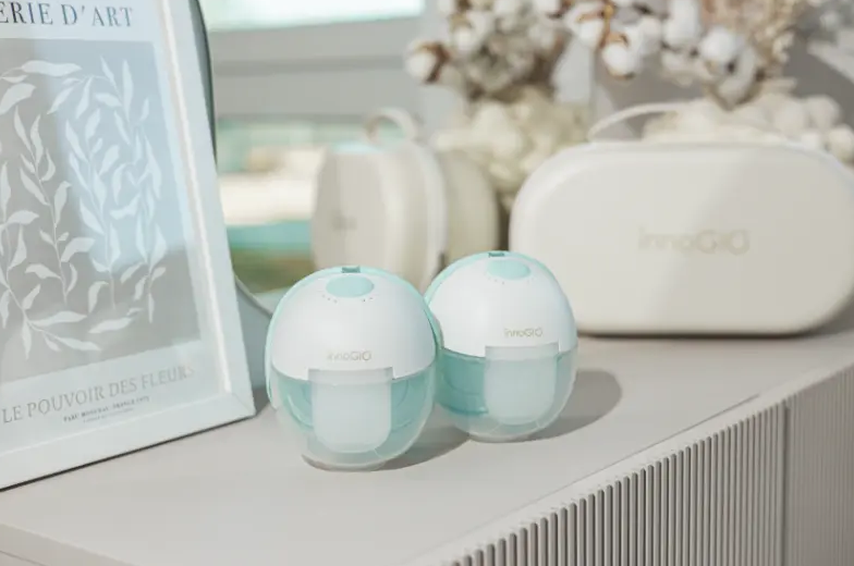 Dwa biało-niebieskie laktatory stoją na półce obok oprawionego plakatu.