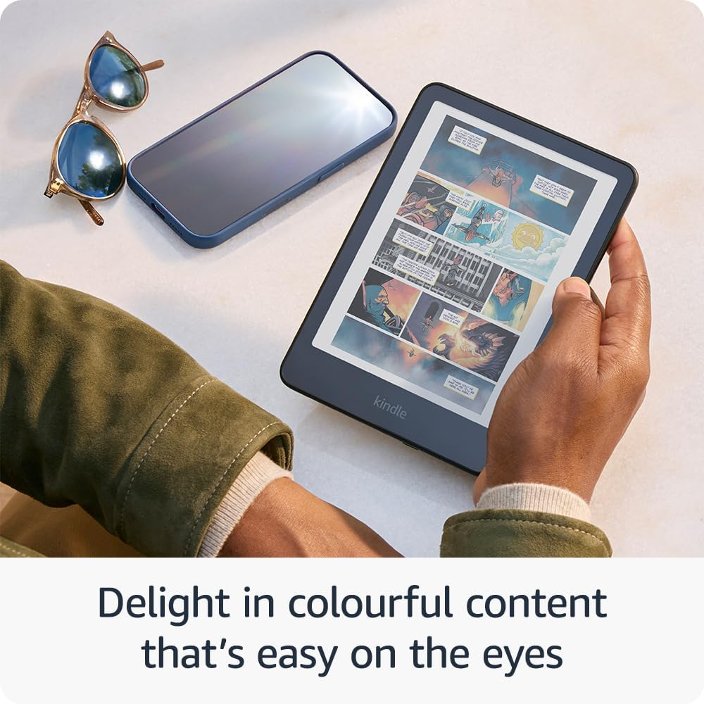 Eine Person hält einen Kindle mit Comic und daneben liegen eine Brille und ein Handy.