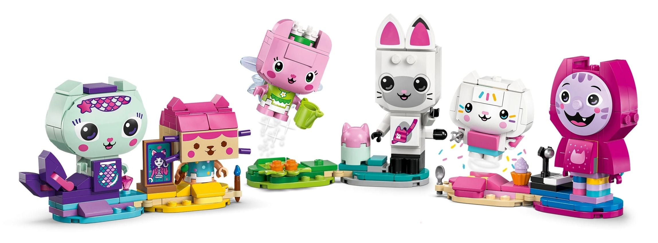 Kolorowe figurki kotów Lego z detalami, takimi jak skrzydła, instrumenty i babeczki.