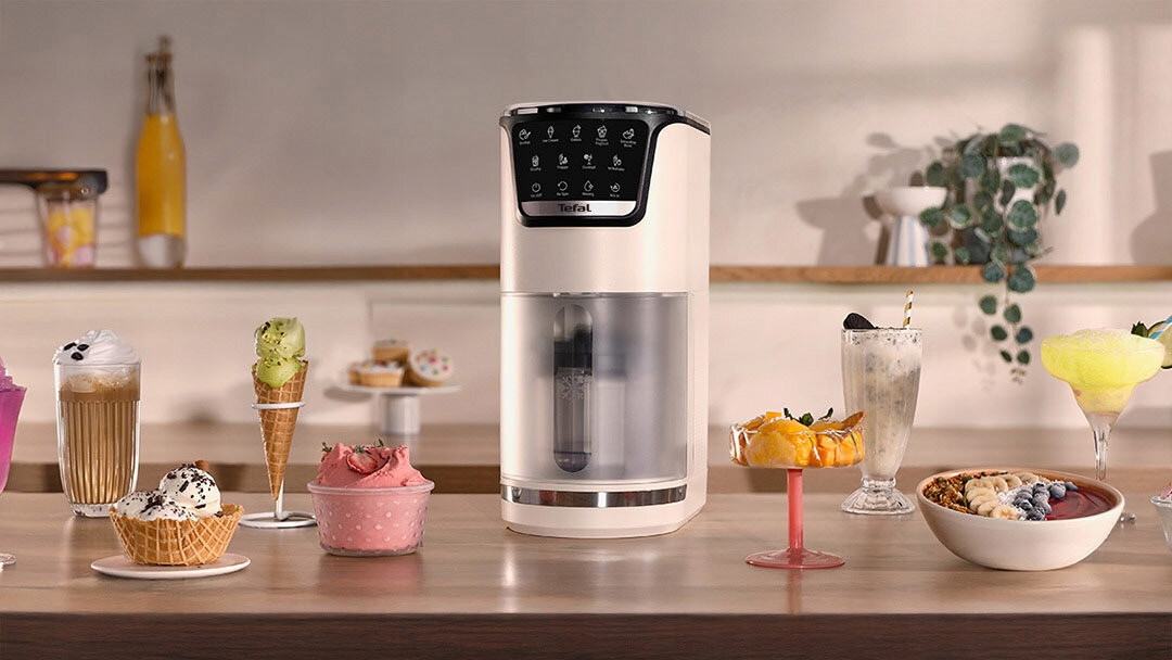 Maszyna do lodów Tefal z lodami, ciastami i napojami na drewnianym blacie.