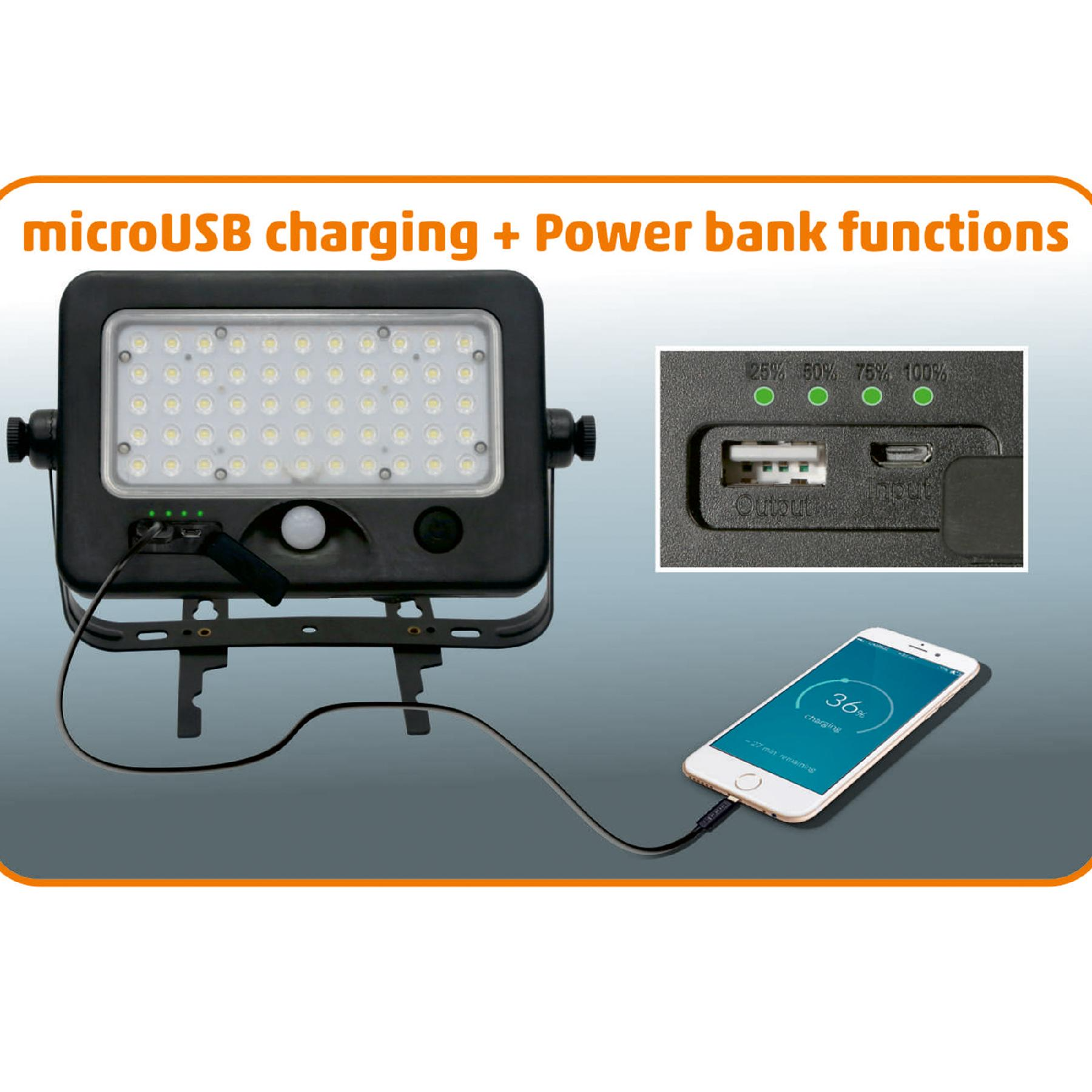 LED-es reflektor USB-kábelen keresztül tölt fel egy okostelefont.