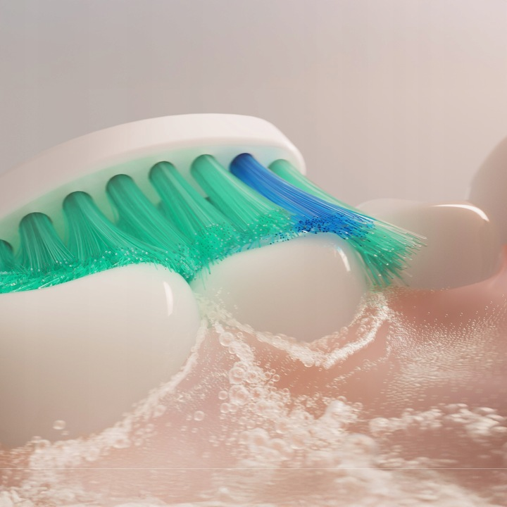 Włosie szczoteczki do zębów czyści białe zęby pianą i bąbelkami.