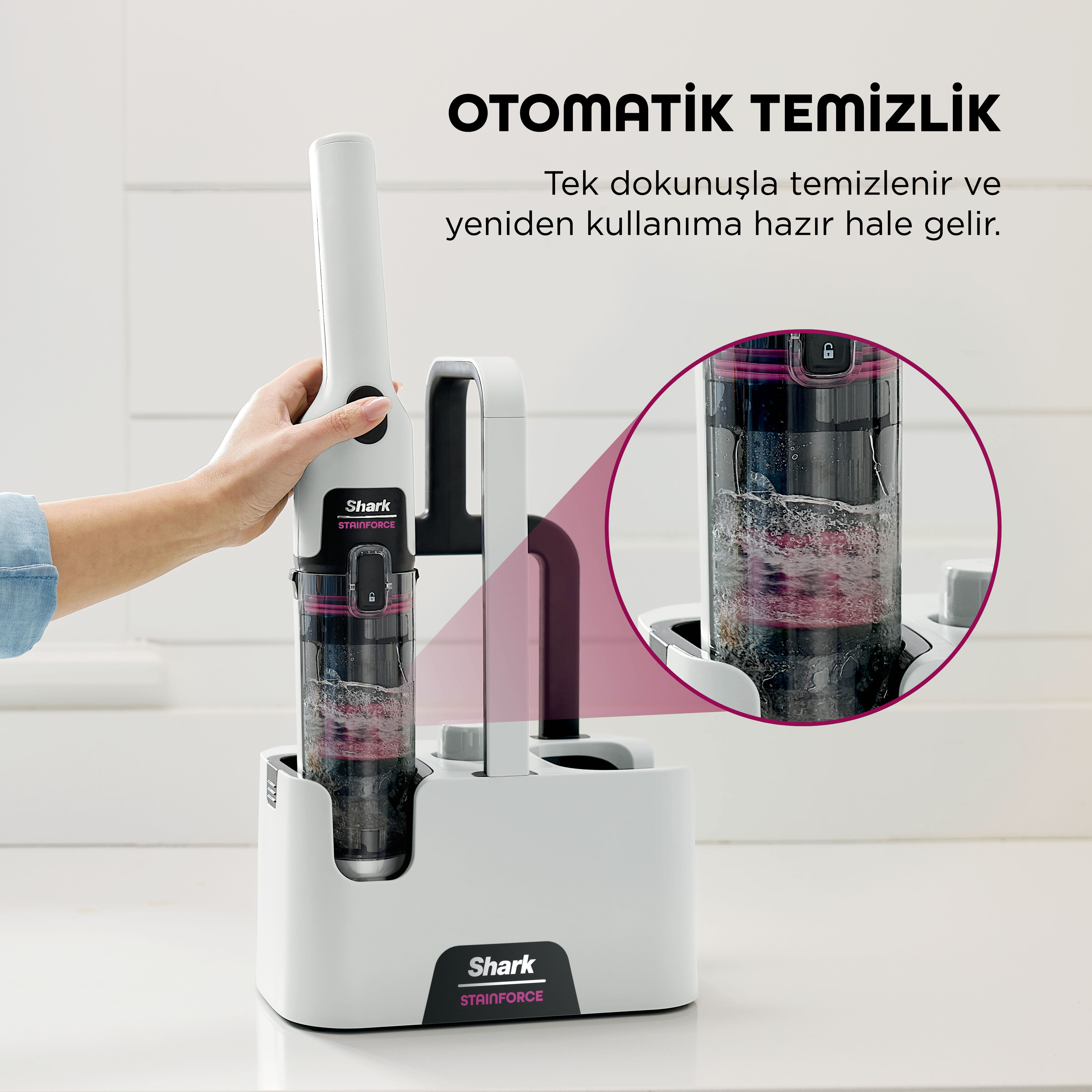 Bir el, içinde sıvı bulunan şeffaf bir hazneye sahip beyaz bir Shark leke çıkarıcı tutuyor.