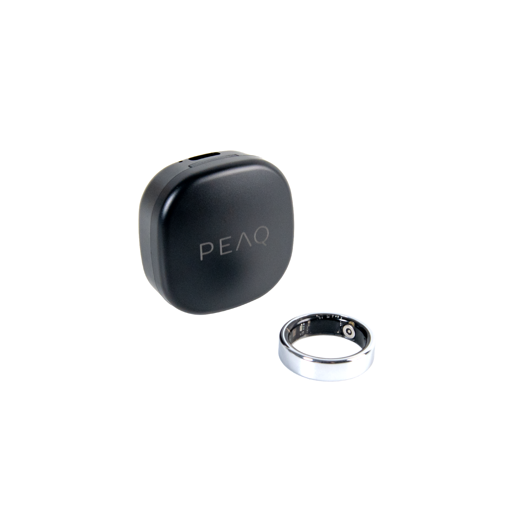 Ein schwarzes PEAQ-Gehäuse und ein silberner Ring liegen nebeneinander.