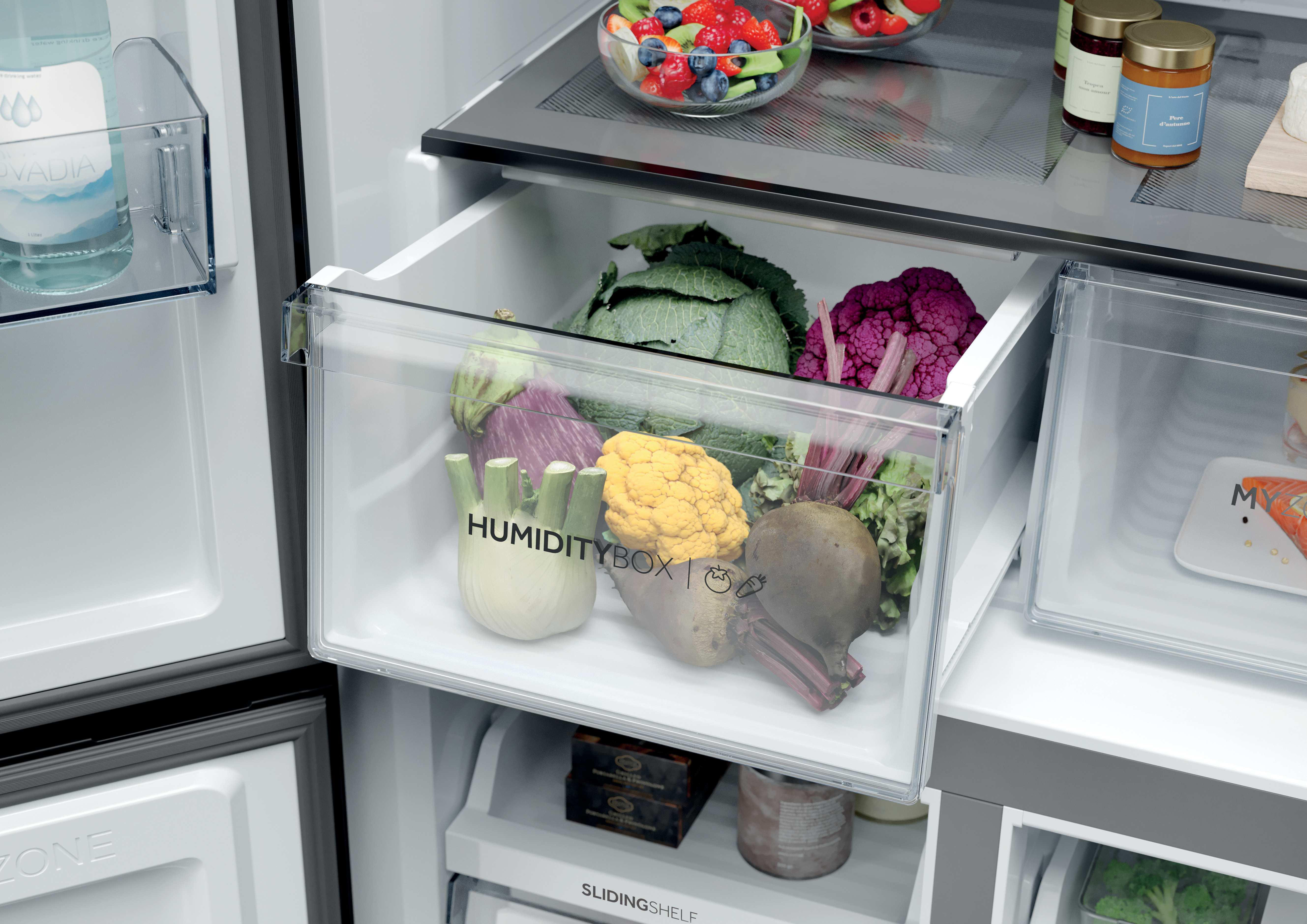 Ein Kühlschrank mit Obst, Gemüse und Gläsern.