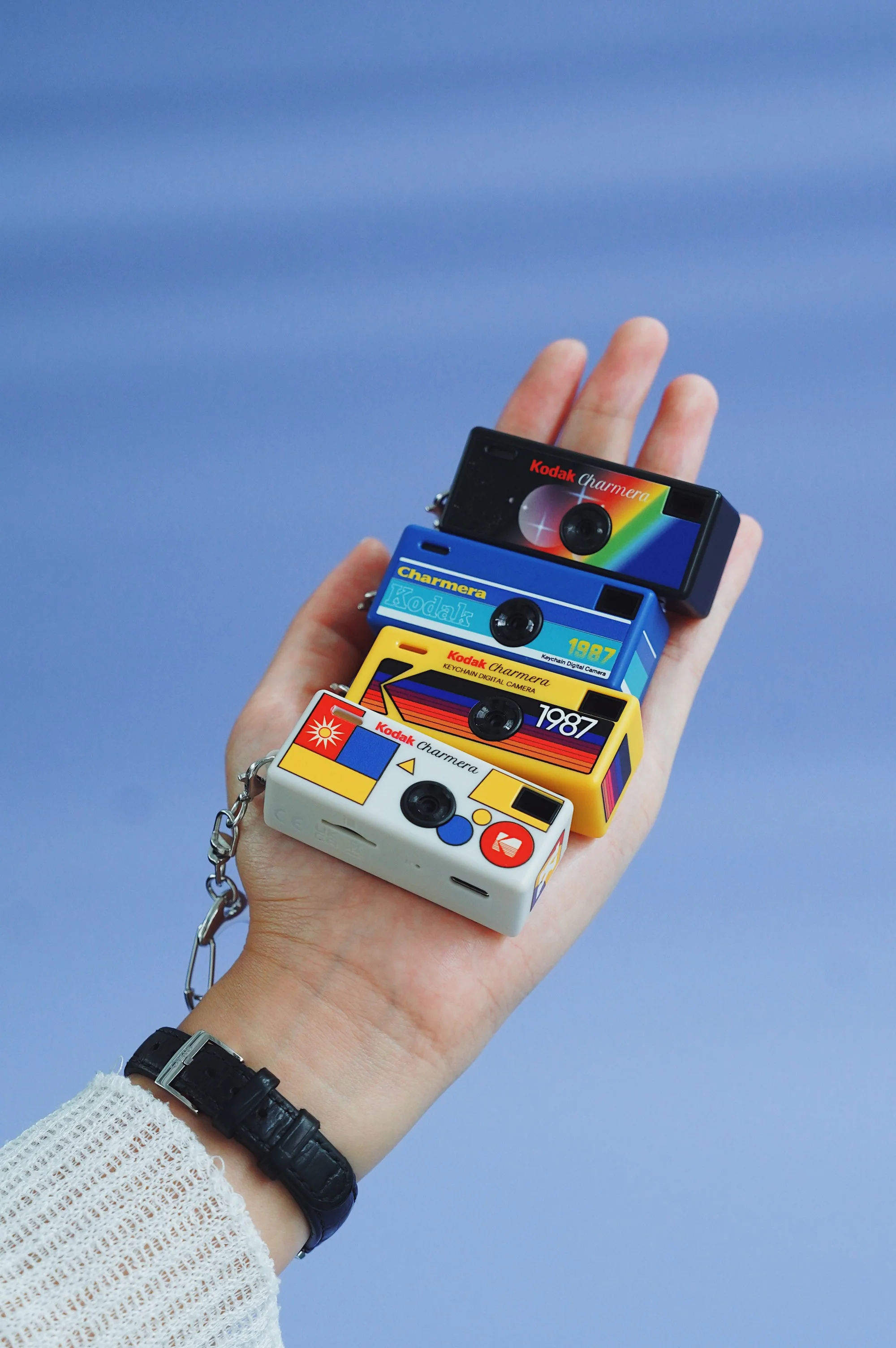 Bir elde tutulan dört minyatür Kodak Charmera anahtarlık kamera.