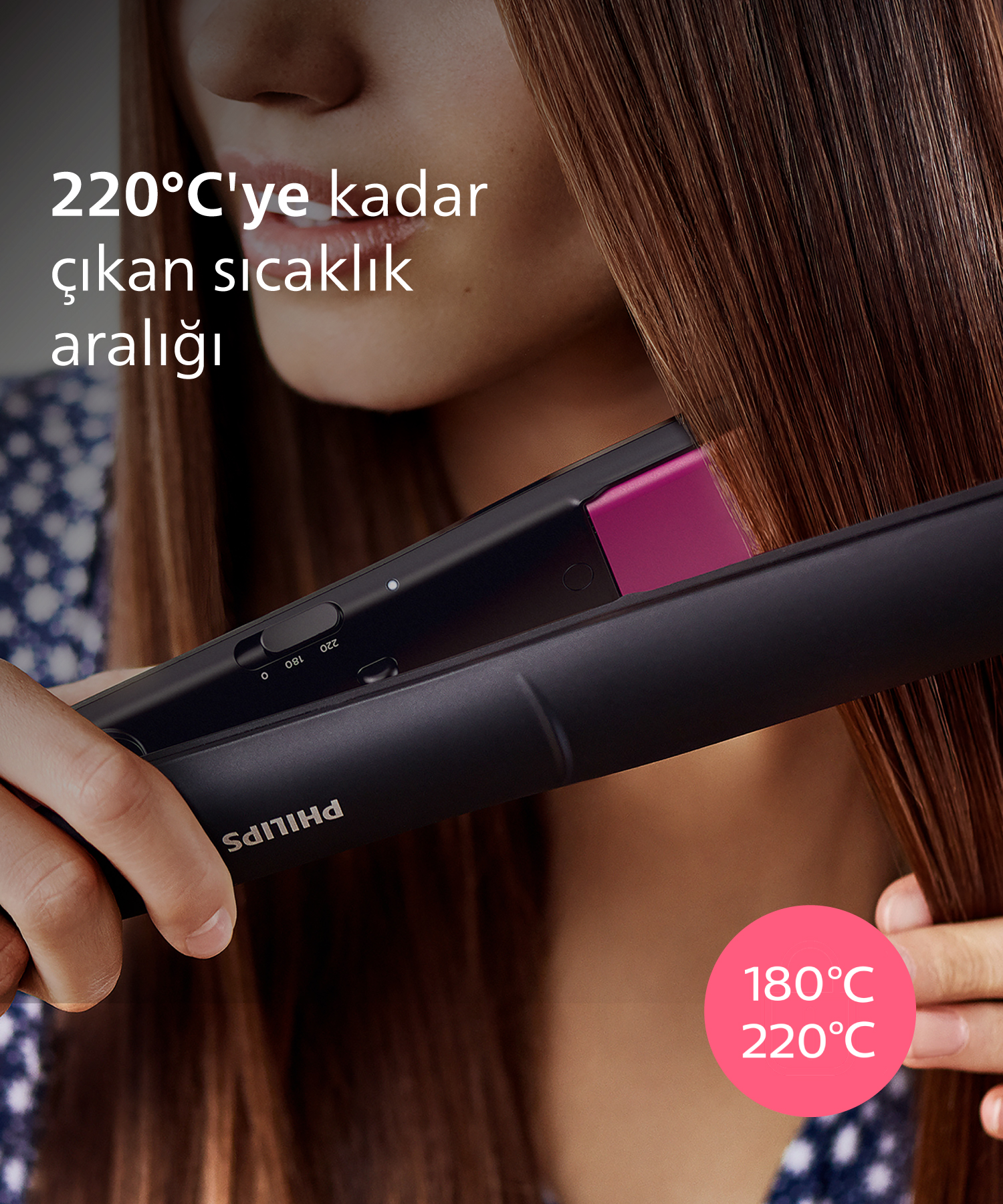 Bir kişi siyah Philips düzleştirici ile kahverengi saçını 180-220°C'de düzleştiriyor.