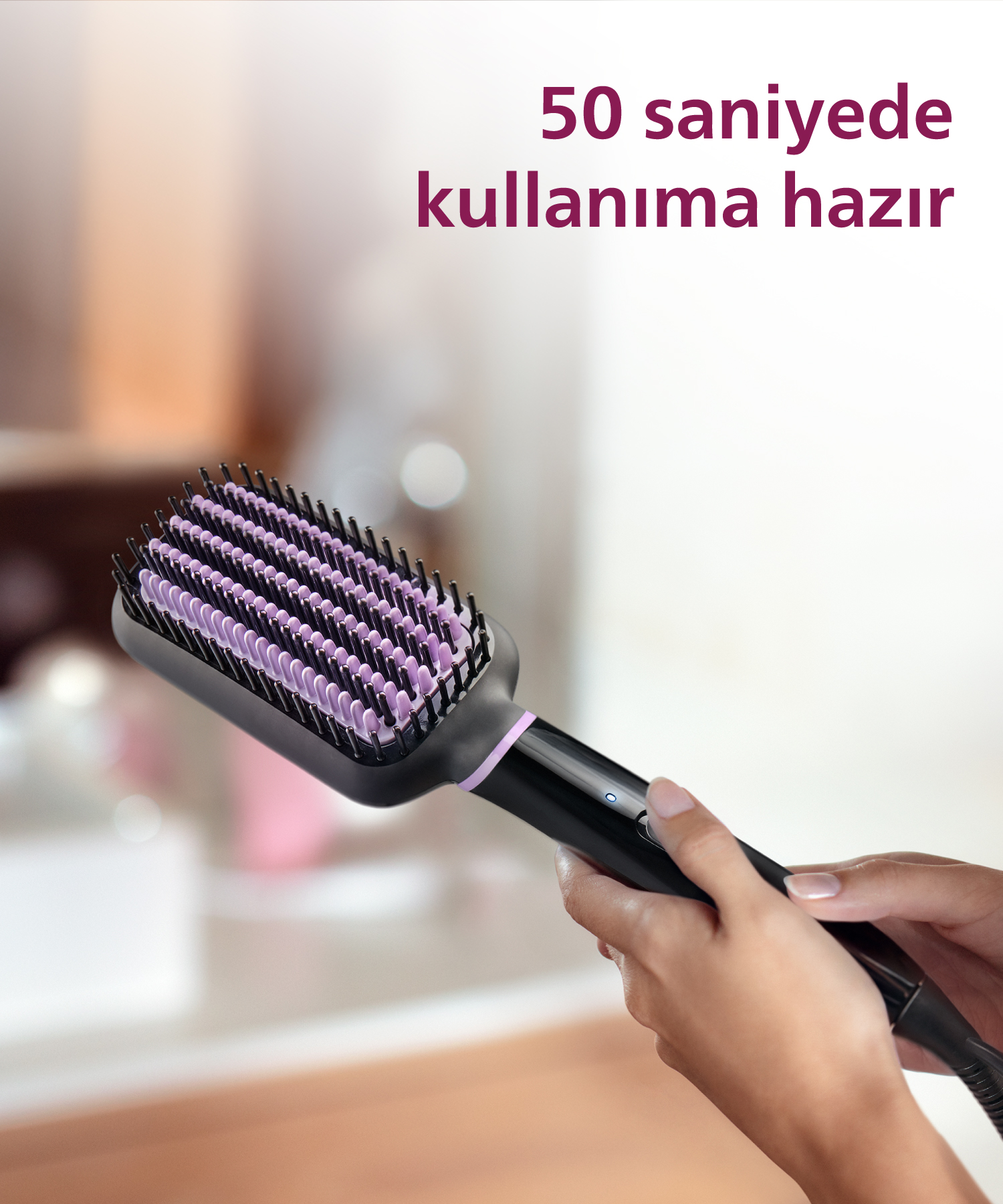 Mor renki dişlere sahip siyah düzleştirici fırça, eller tarafından tutuluyor.