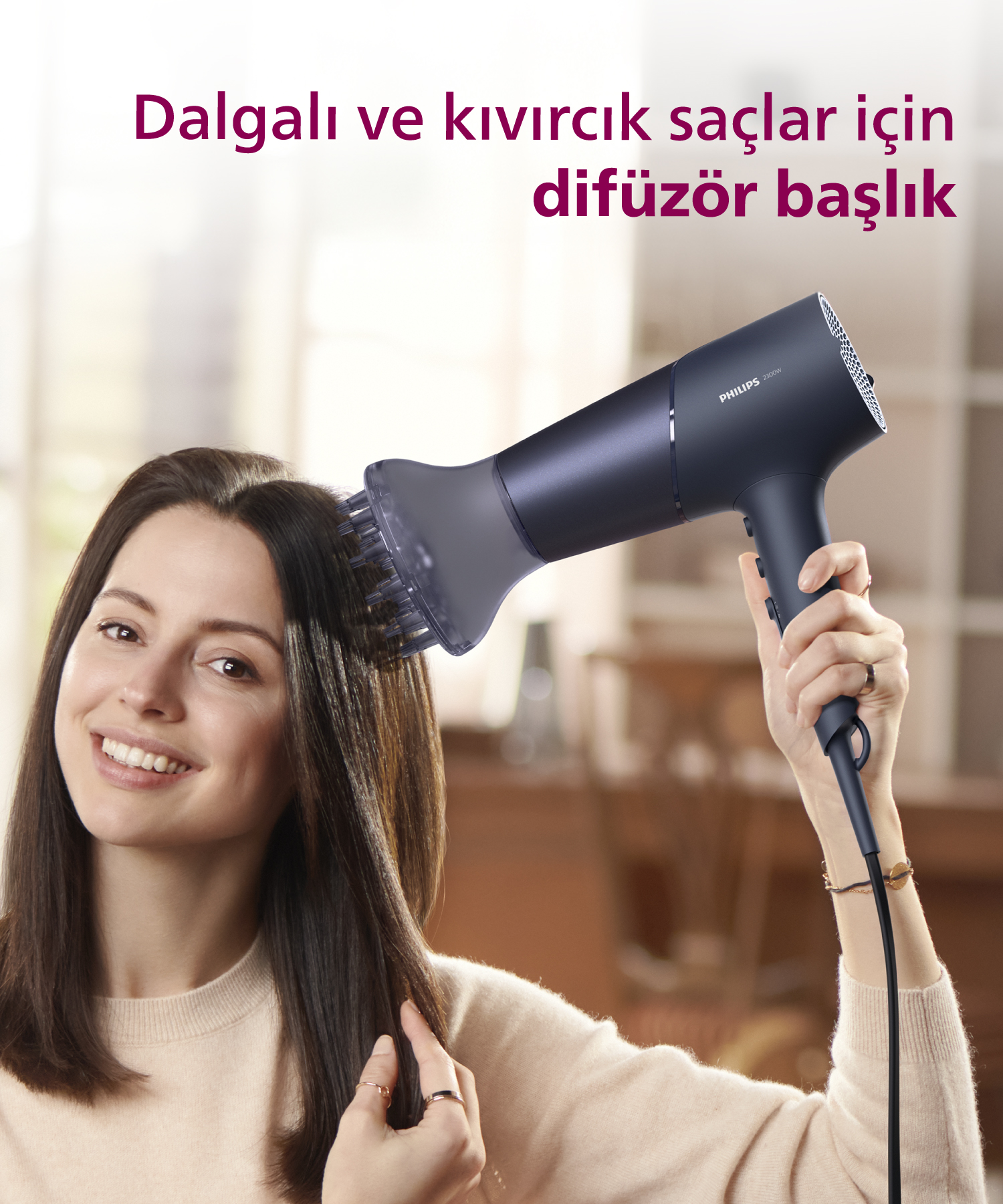 Kadın gülümseyerek kahverengi saçlarını siyah difüzör başlığıyla kurutuyor.