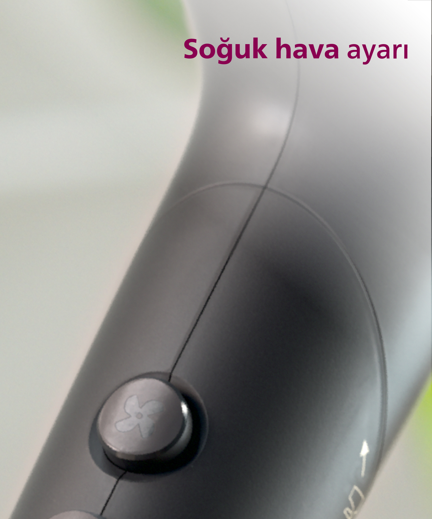 Saç kurutma makinesinin yakın çekimi, üzerinde fan simgesi bulunan gümüş bir düğme ve "Soğuk hava ayarı" yazısı görünüyor.