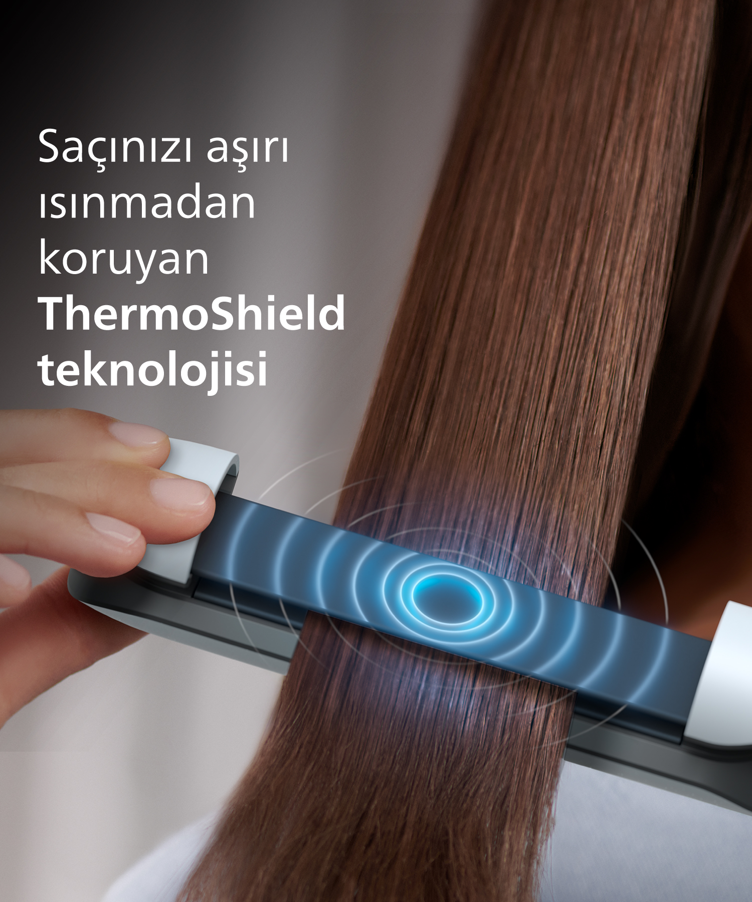 Bir el, kahverengi saçlarda ThermoShield teknolojili saç düzleştirici kullanıyor.