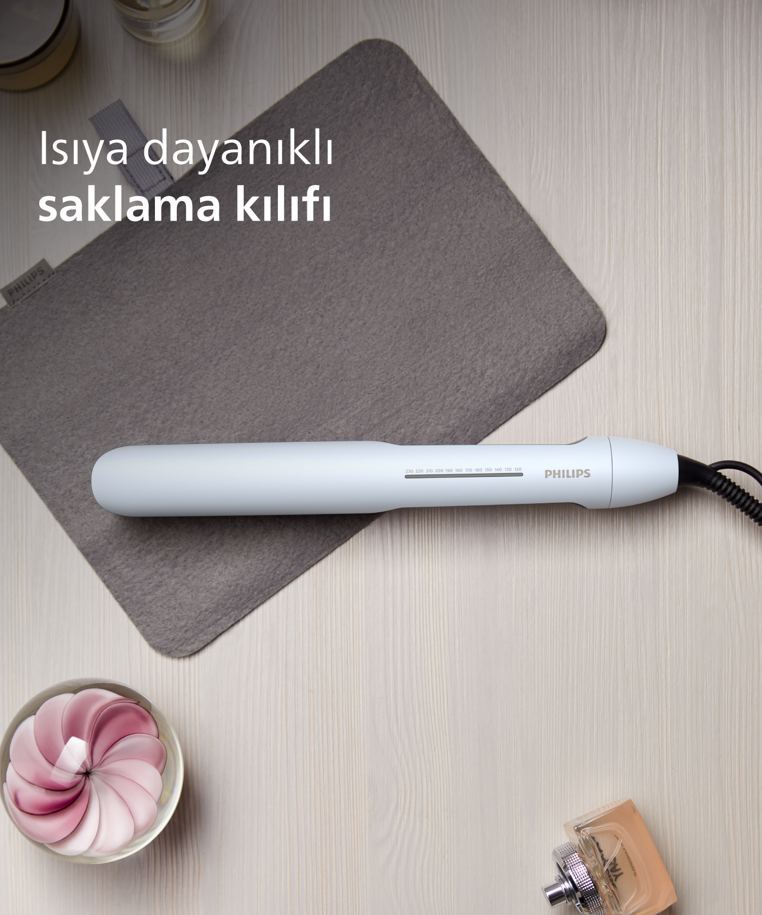 Beyaz Philips düzleştirici, gri ısıya dayanıklı bir kılıfın üzerinde duruyor.