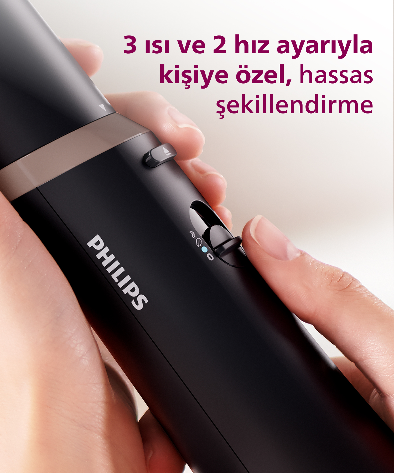 Ayarlı düğmesi olan siyah Philips tıraş makinesinin elle tutulmuş yakın çekimi.