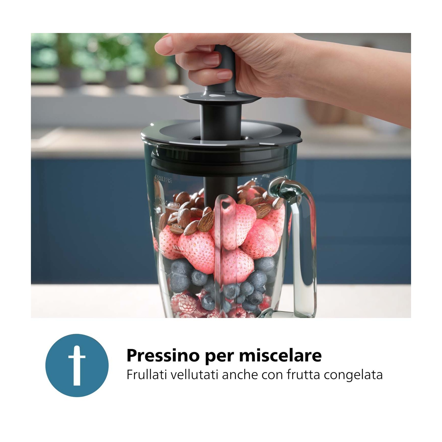 Una mano preme lo stantuffo in un frullatore con bacche, fragole e mandorle.