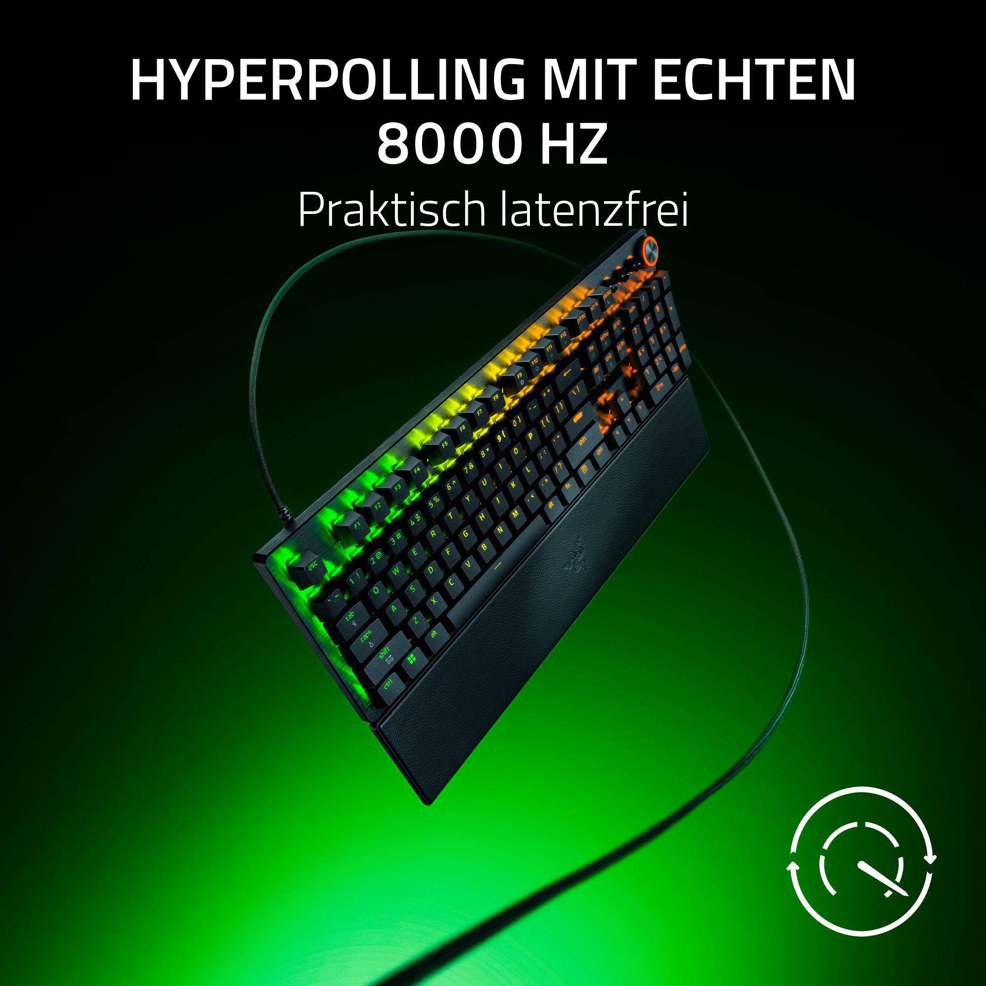 Ein schwarzes Gaming-Keyboard mit grüner und oranger Beleuchtung auf dunklem Hintergrund.