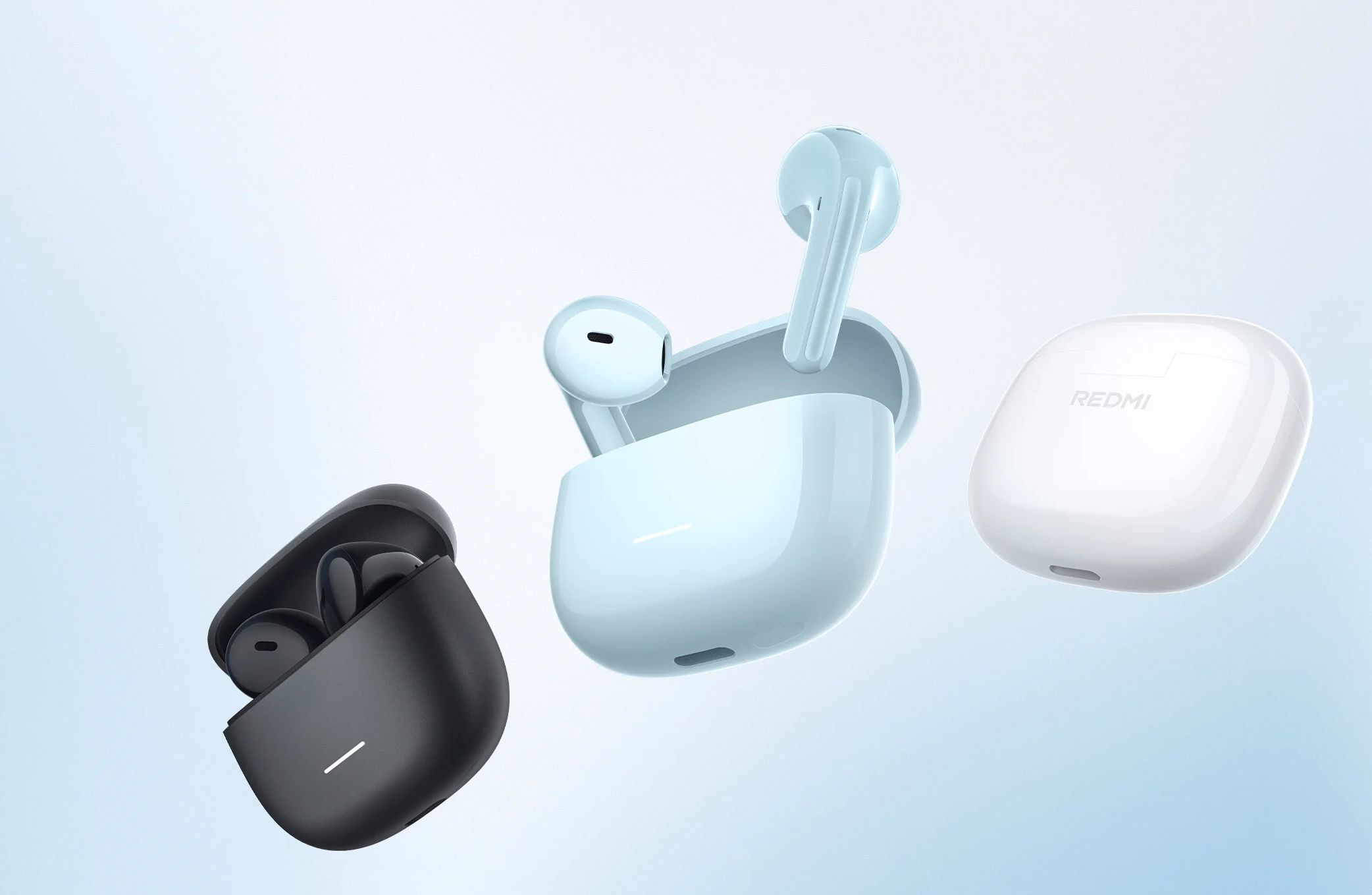Trzy bezprzewodowe słuchawki w kolorach czarnym, jasnoniebieskim i białym na niebieskim tle.