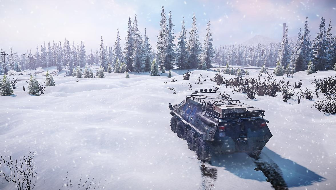 Ein schweres Fahrzeug fährt durch eine verschneite Landschaft mit Bäumen.