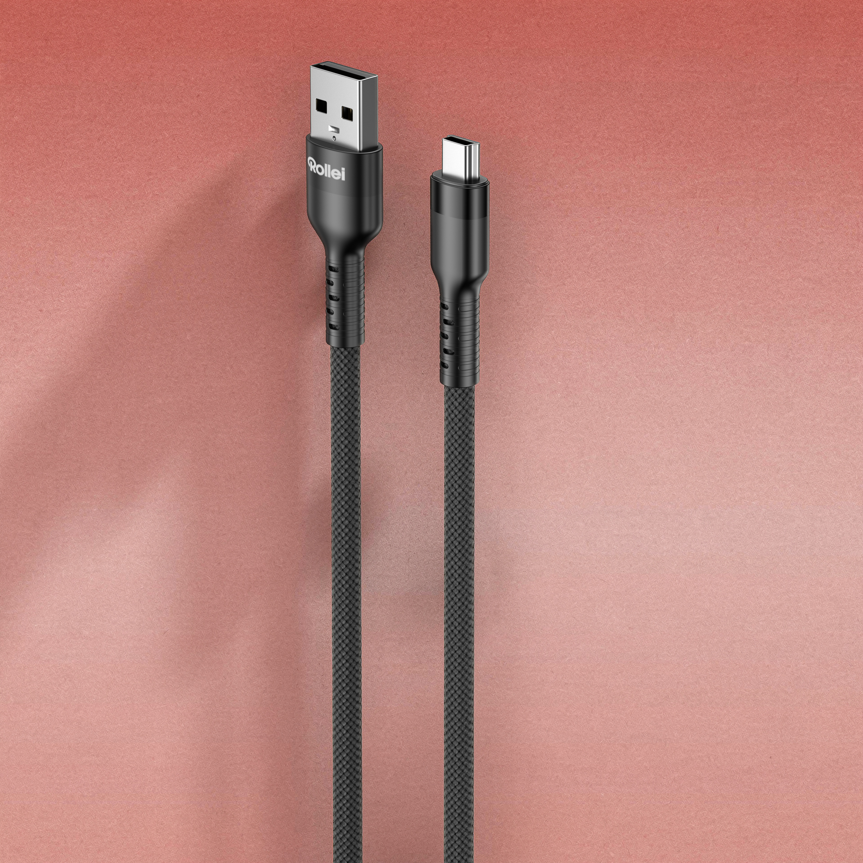 Ein schwarzes USB-A-zu-USB-C-Kabel mit Stoffummantelung auf rosafarbenem Hintergrund.