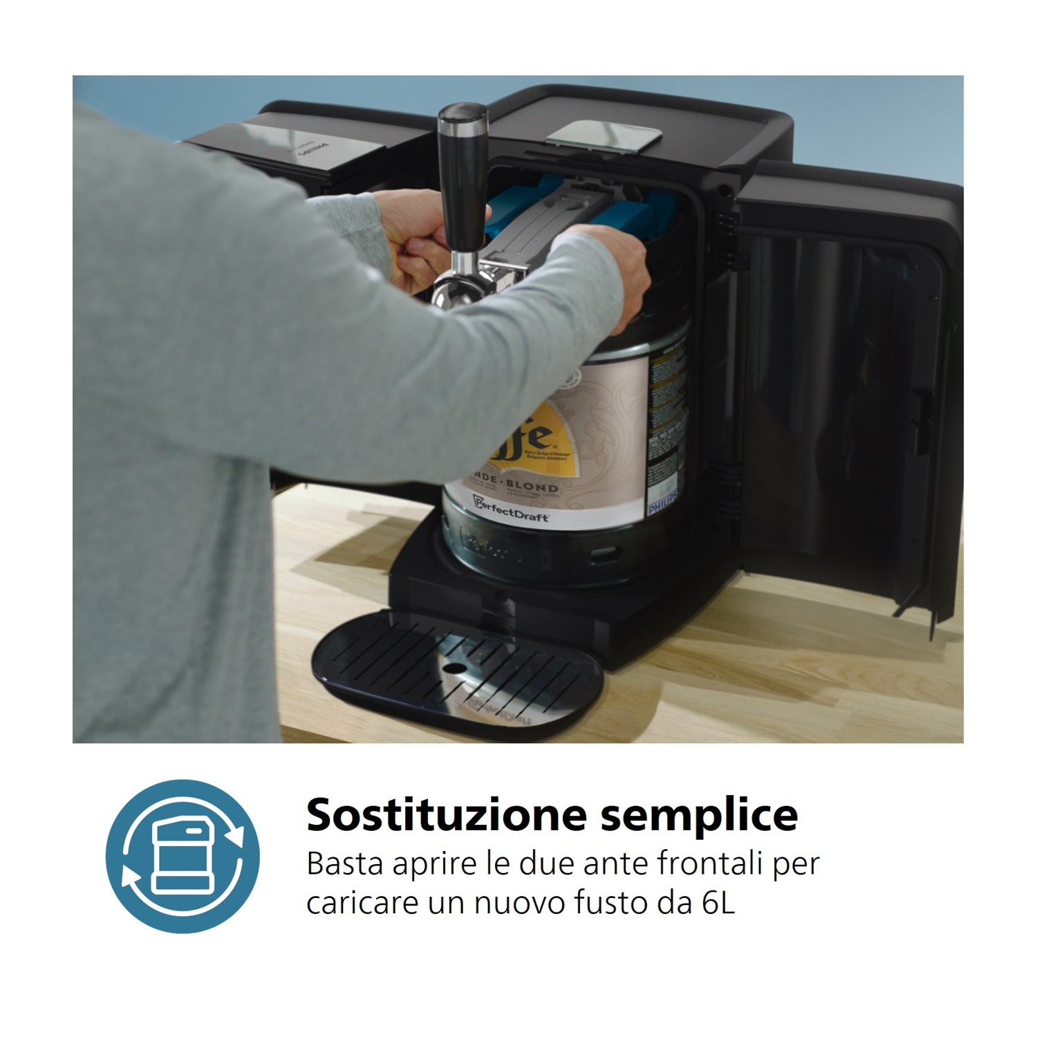 Una persona carica un fusto di birra in un dispenser nero.