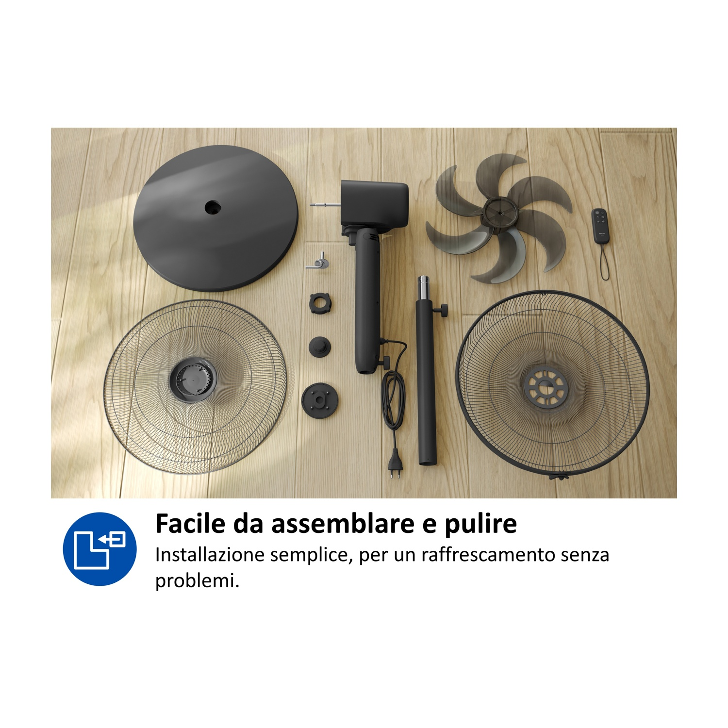 Parti di un ventilatore da terra nero disposte su un pavimento in legno.