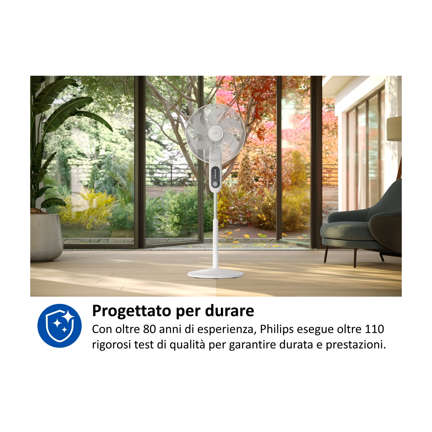 Un ventilatore da terra bianco in una stanza luminosa con grandi finestre.