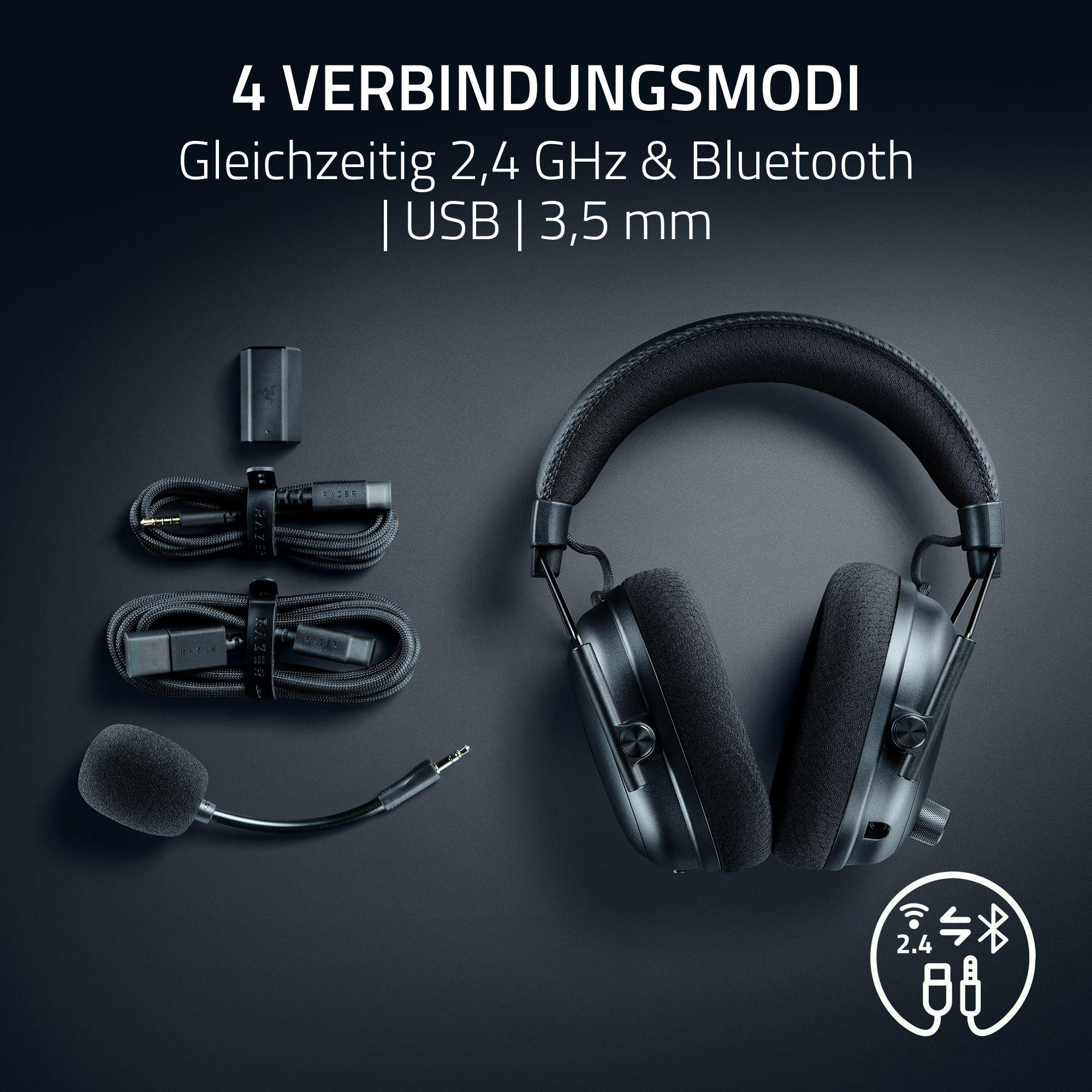 Schwarze Kopfhörer mit Kabeln, Mikrofon und USB-Dongle auf dunklem Grund.
