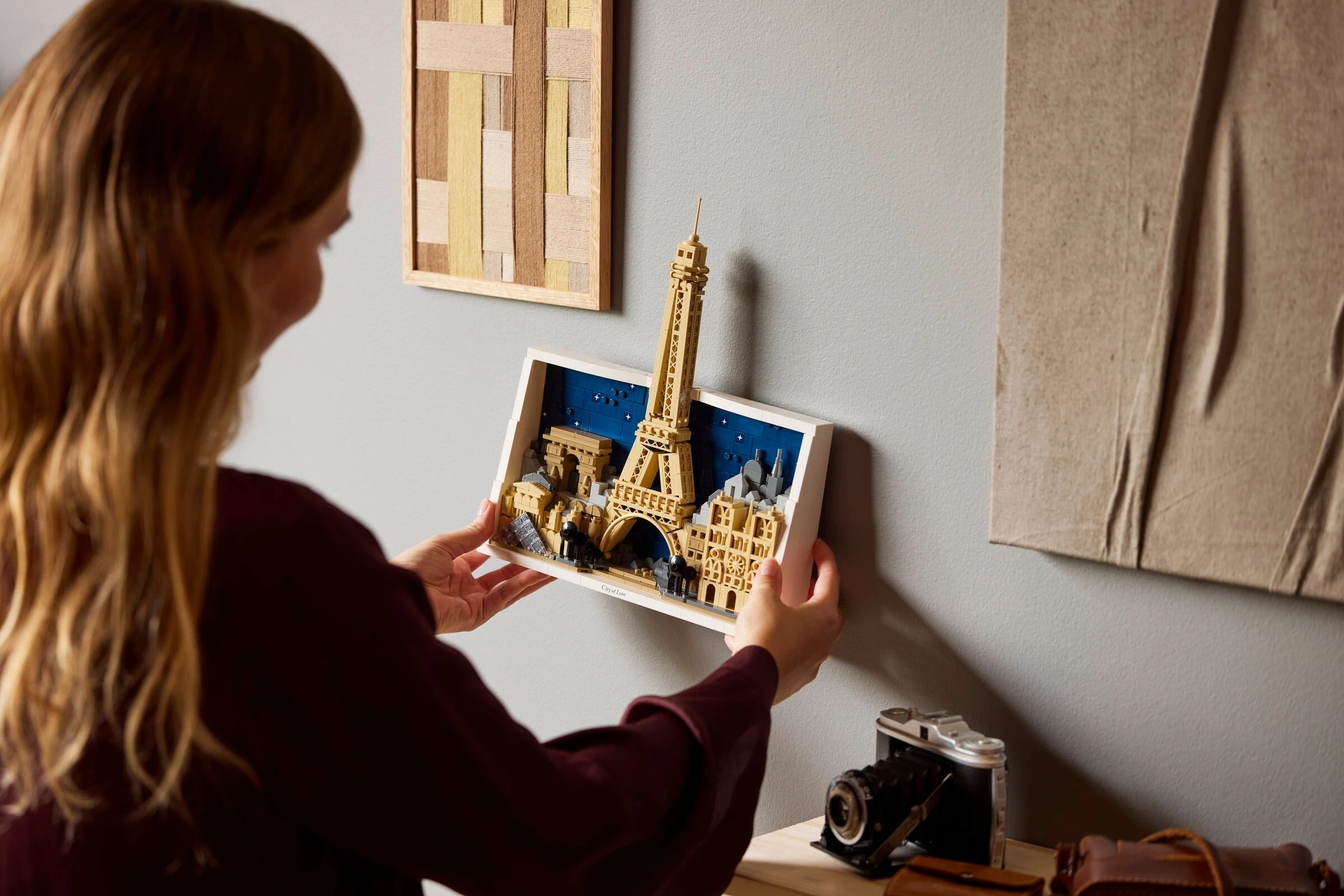 Kobieta trzymająca model Lego Wieży Eiffla i Paryża.