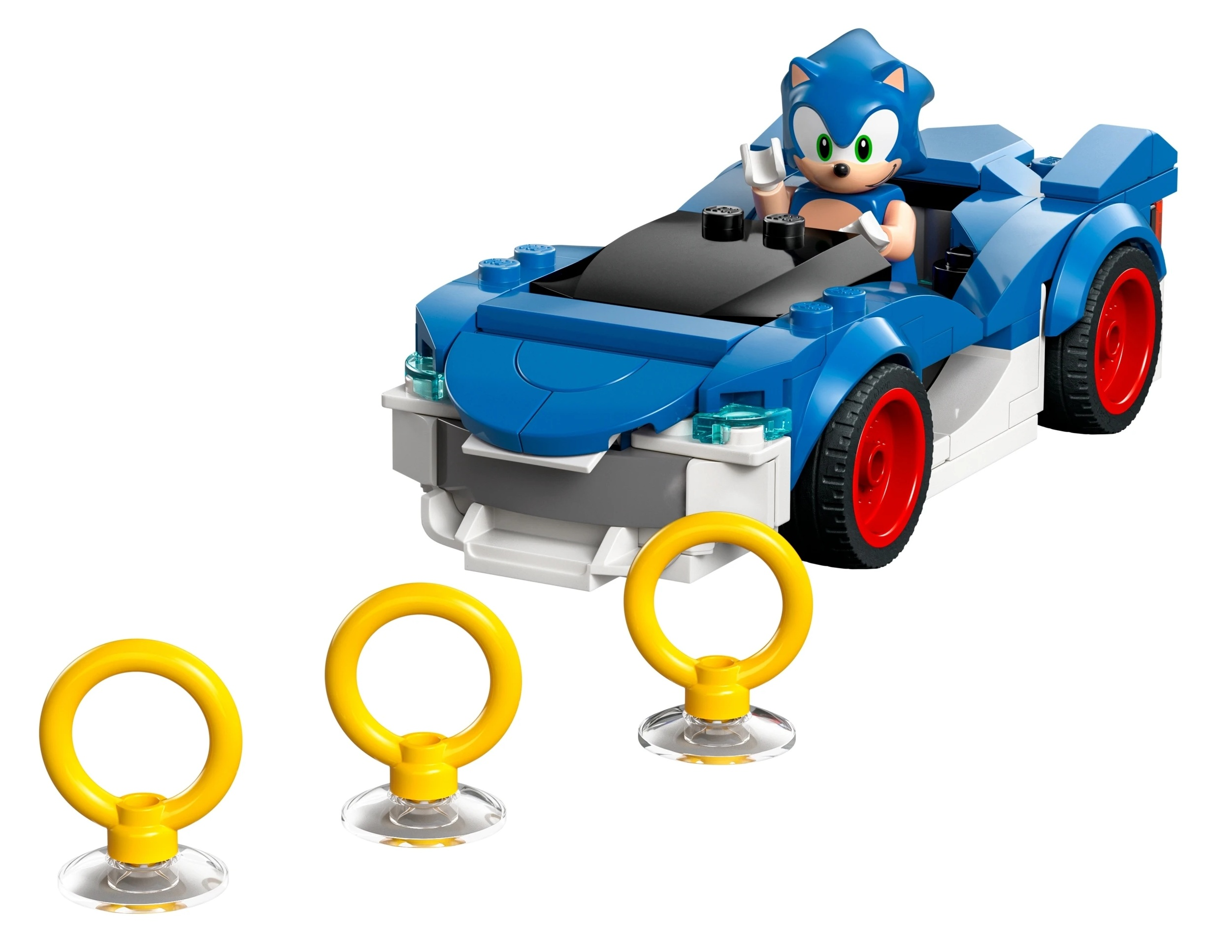 Sonic siedzi w niebieskim samochodzie Lego z czerwonymi kołami. Trzy złote pierścienie z przodu.