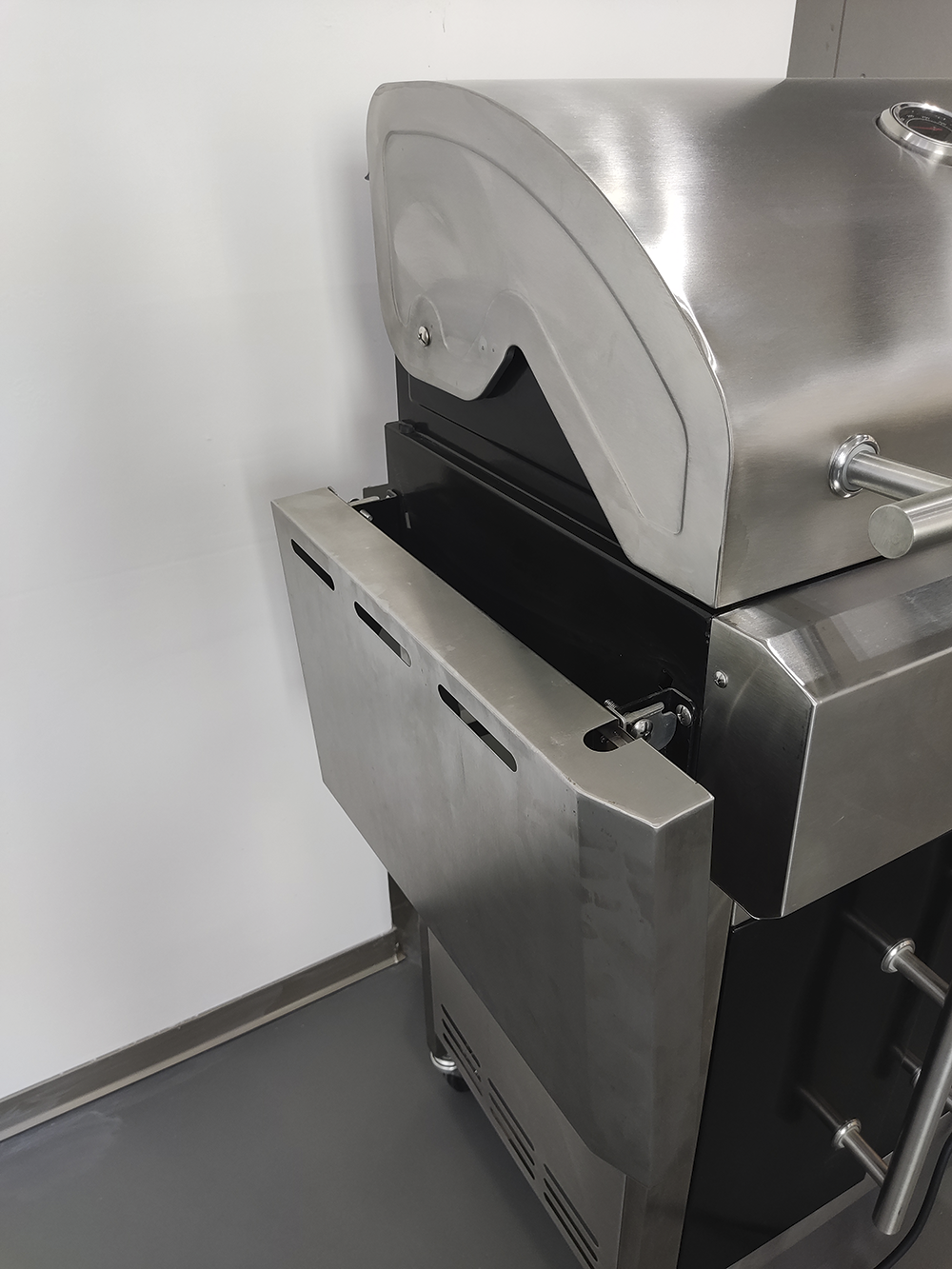 Edelstahlgrill mit offenem Ablagefach und silbernem Griff.