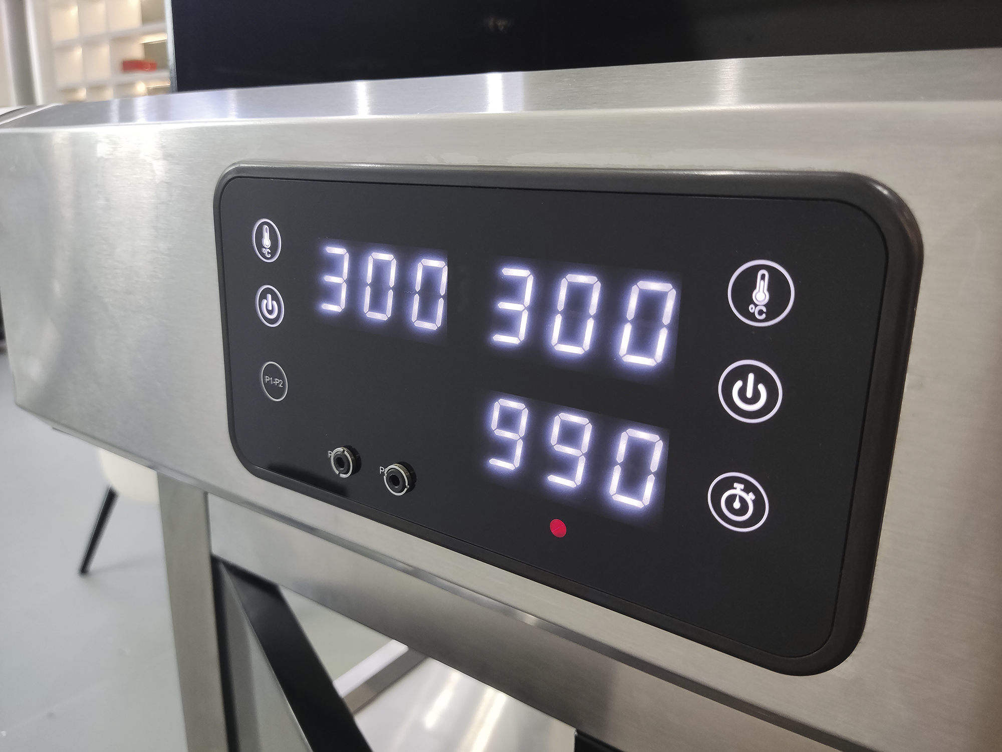 Digitalanzeige mit Zahlen 300 300 und 990, Thermometer- und Power-Symbol.