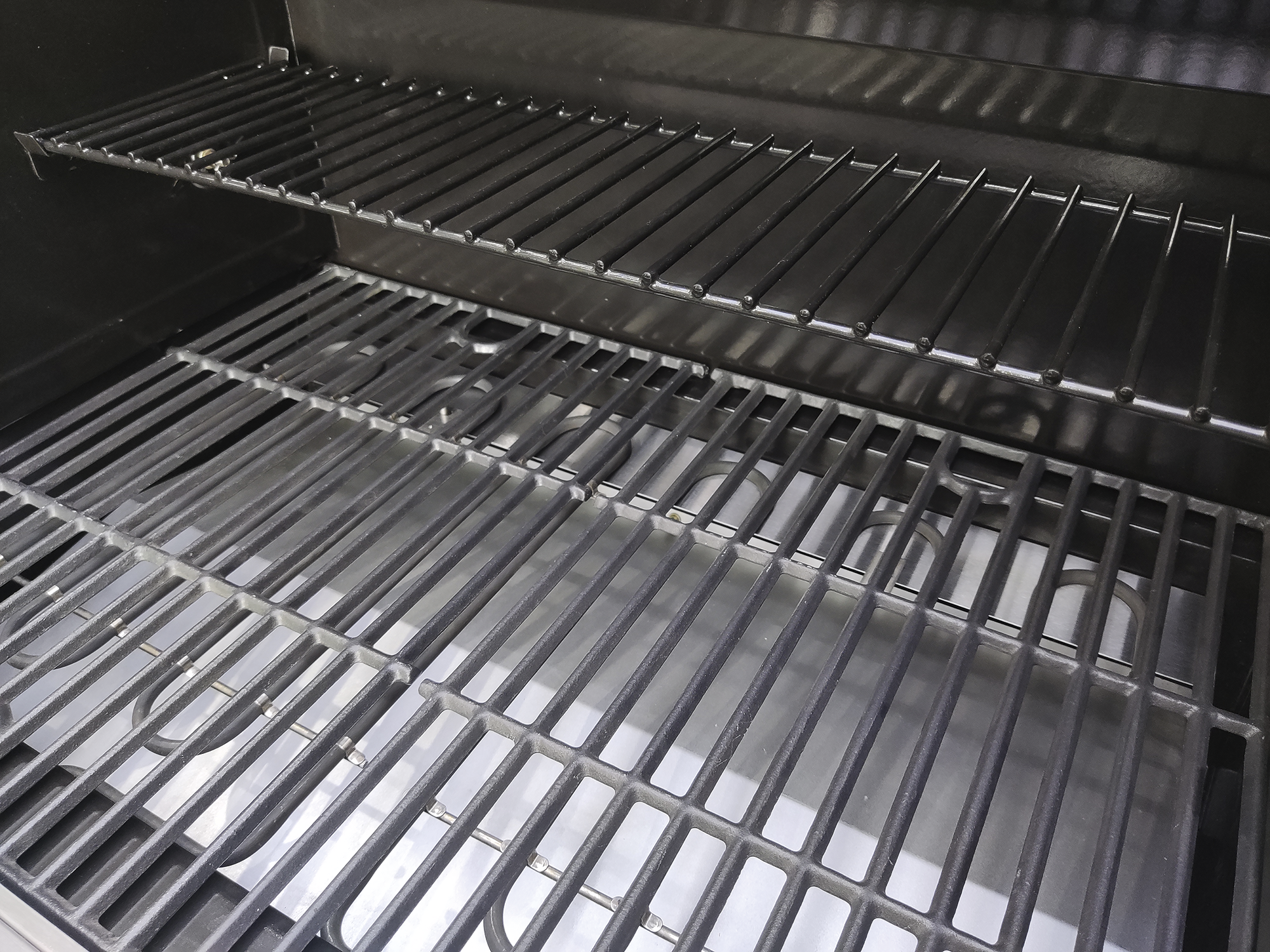 Zwei leere Grillroste übereinander in einem Grill.