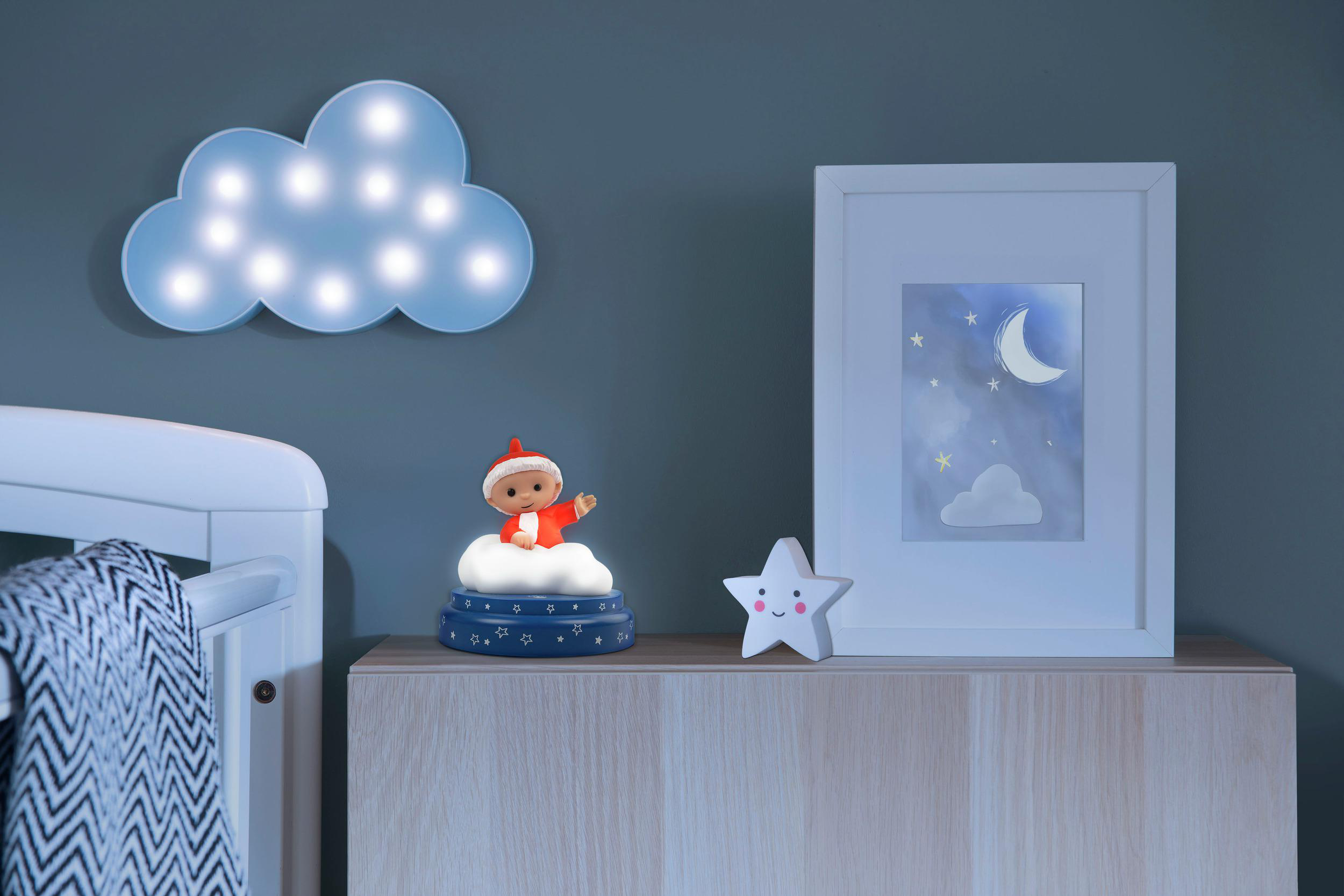 Ein Nachtlicht in Wolkenform beleuchtet die Wand über einem Kinderbett.