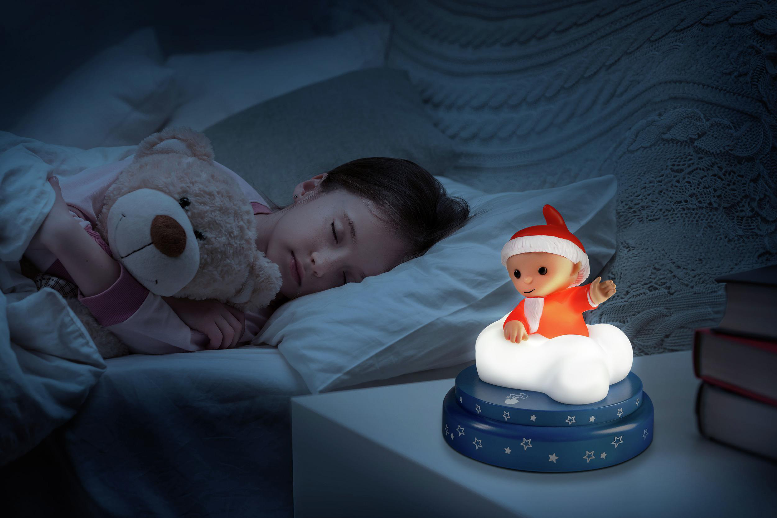 Ein Kind schläft im Bett mit einem Teddybär. Ein Nachtlicht leuchtet.
