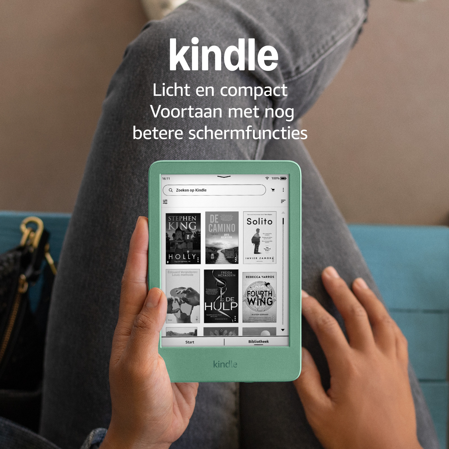 A person holds a light green Kindle device showing book covers and text.