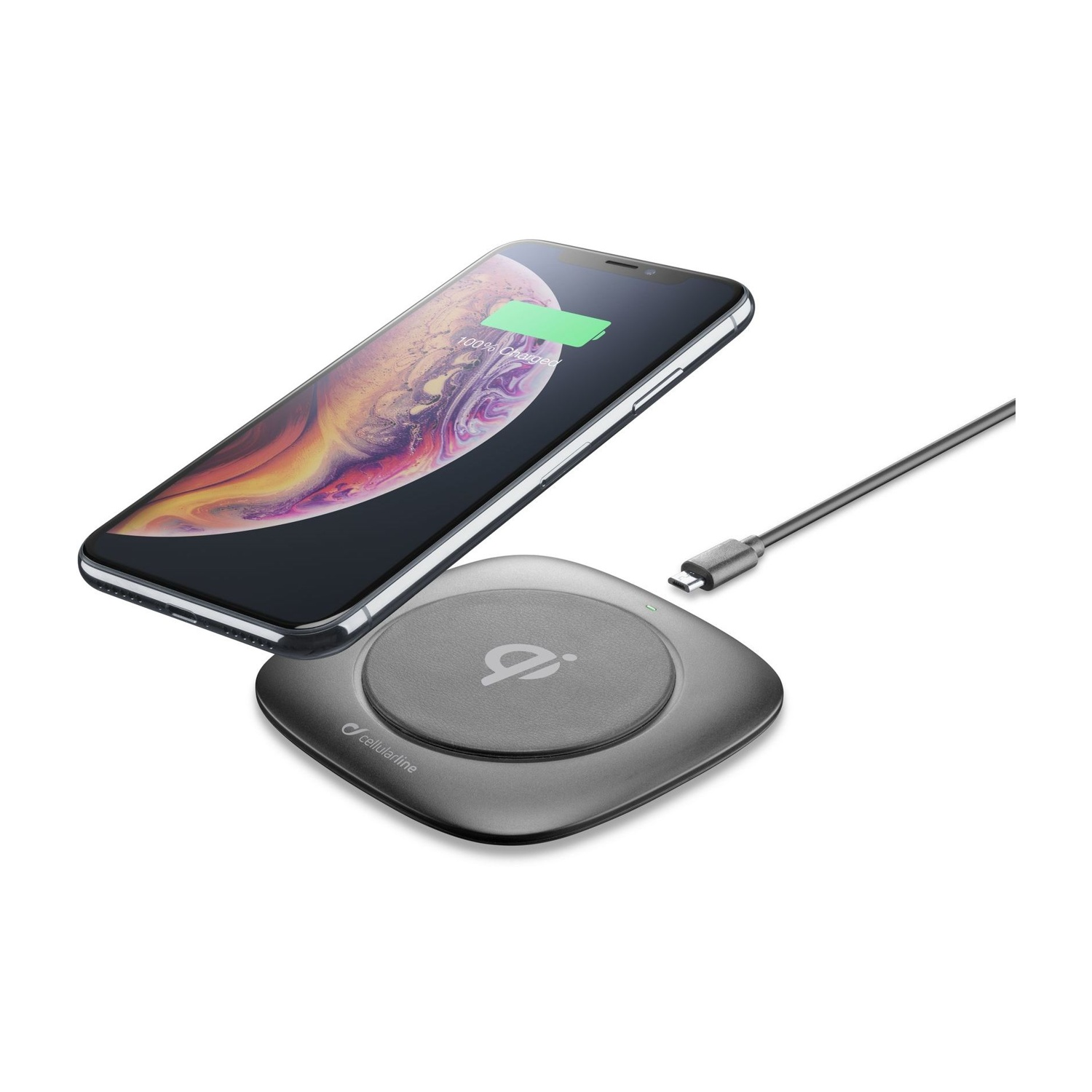 Uno smartphone si ricarica su un pad di ricarica wireless grigio. Un cavo USB-C è vicino.