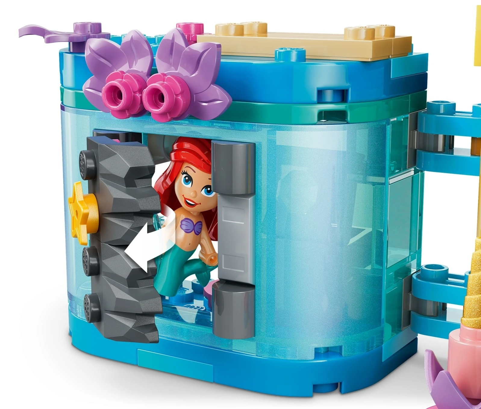 Figurka Ariel w niebieskim zamku Lego z fioletowymi kwiatami i szarymi skałami.