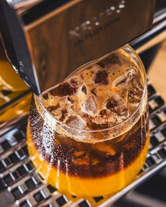 Przygotowywany jest napój z kostkami lodu i sokiem pomarańczowym.