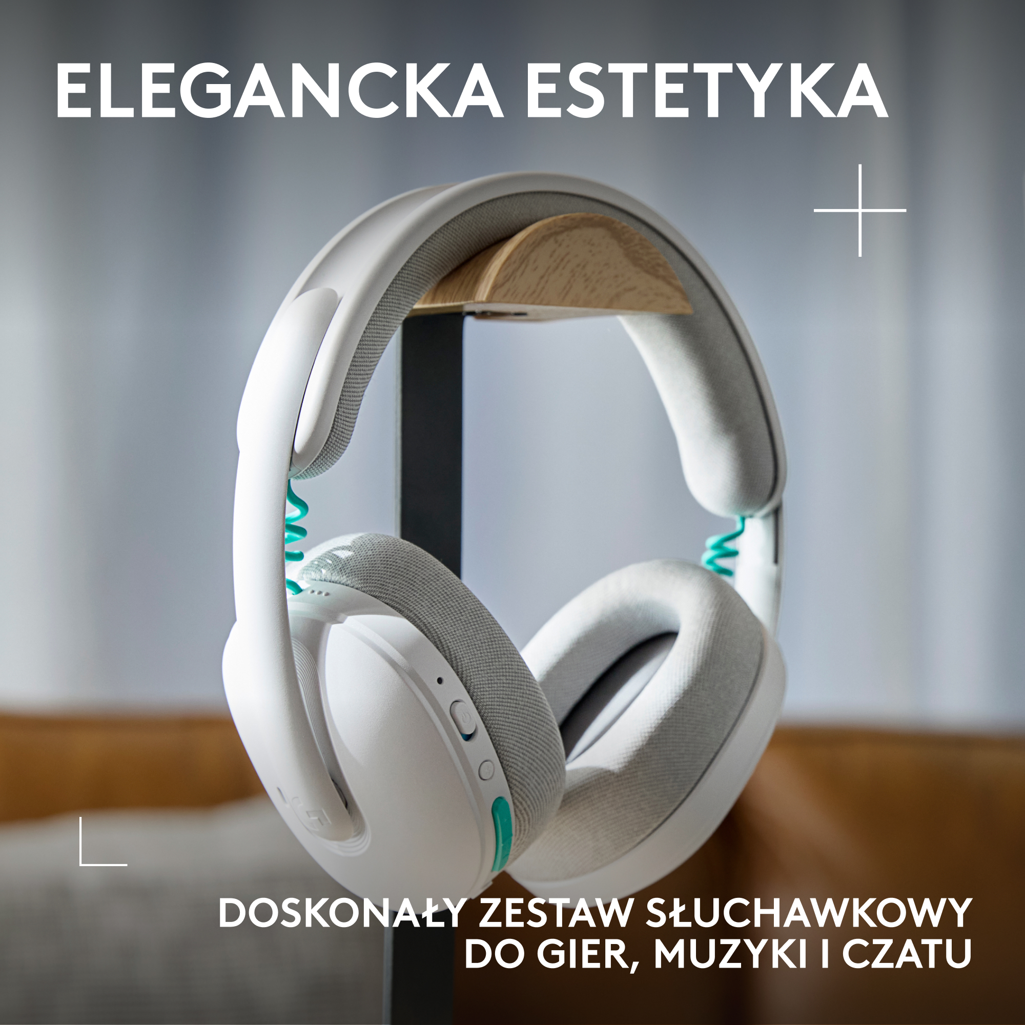 Białe słuchawki z szarym wykończeniem i turkusowymi akcentami na stojaku.