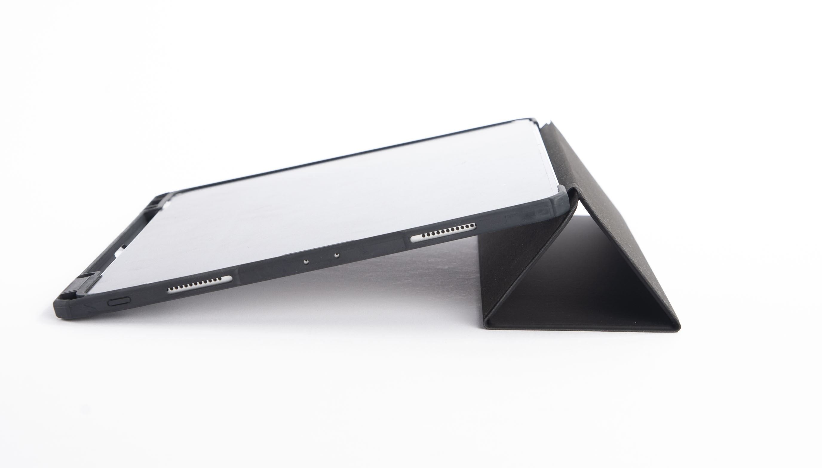 Ein schwarzes Tablet mit einem klappbaren Ständer, das auf einer weißen Fläche liegt.