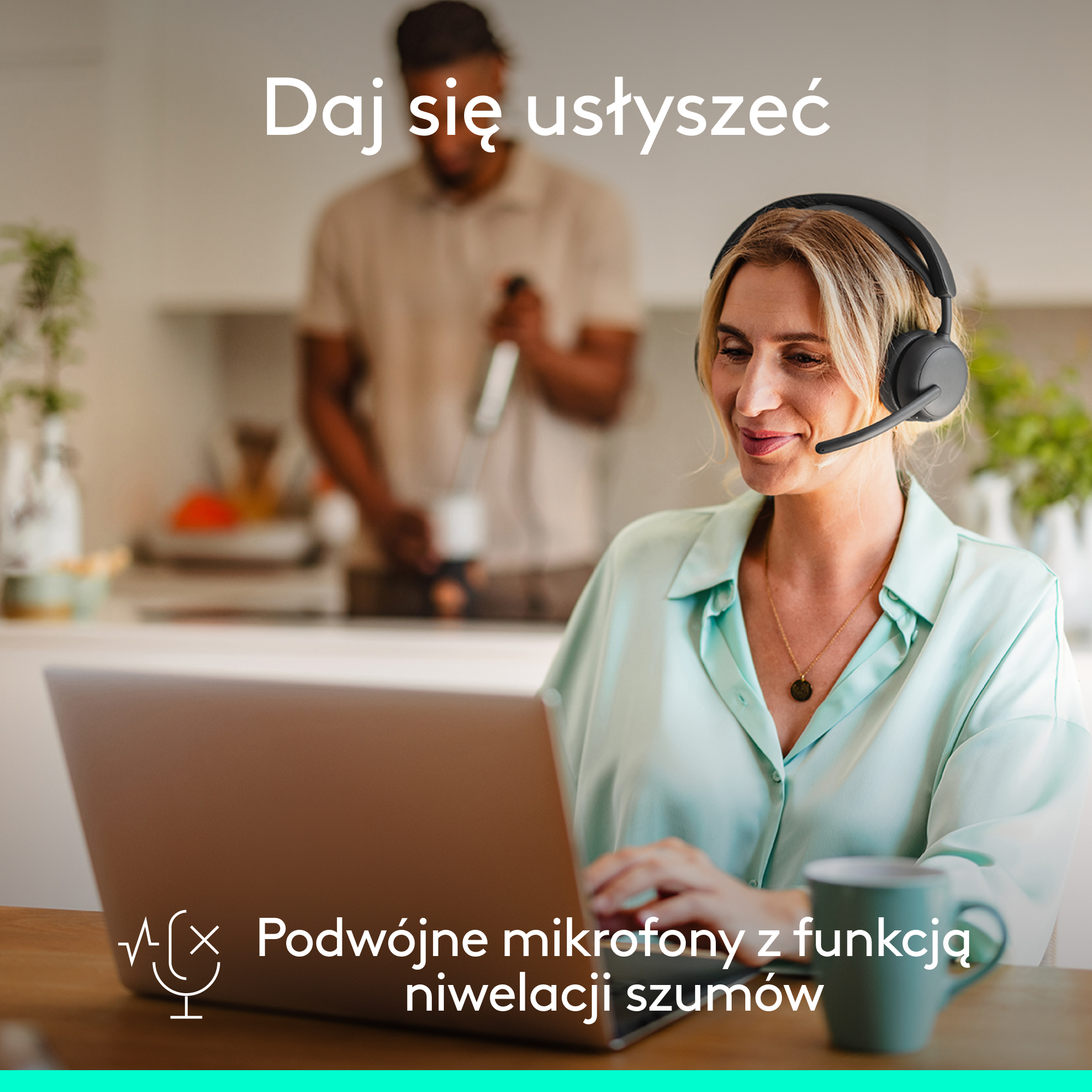 Kobieta w słuchawkach patrzy na laptopa. W tle mężczyzna w kuchni.