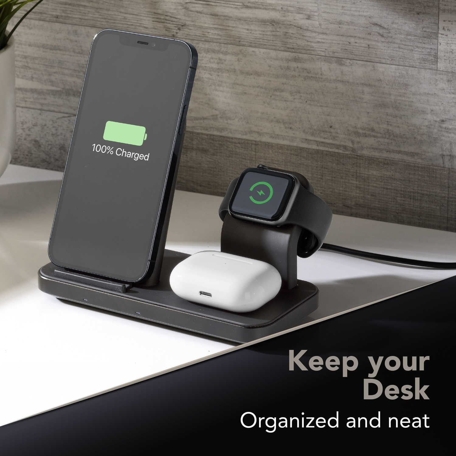 Un supporto di ricarica nero con iPhone, Apple Watch e AirPods.