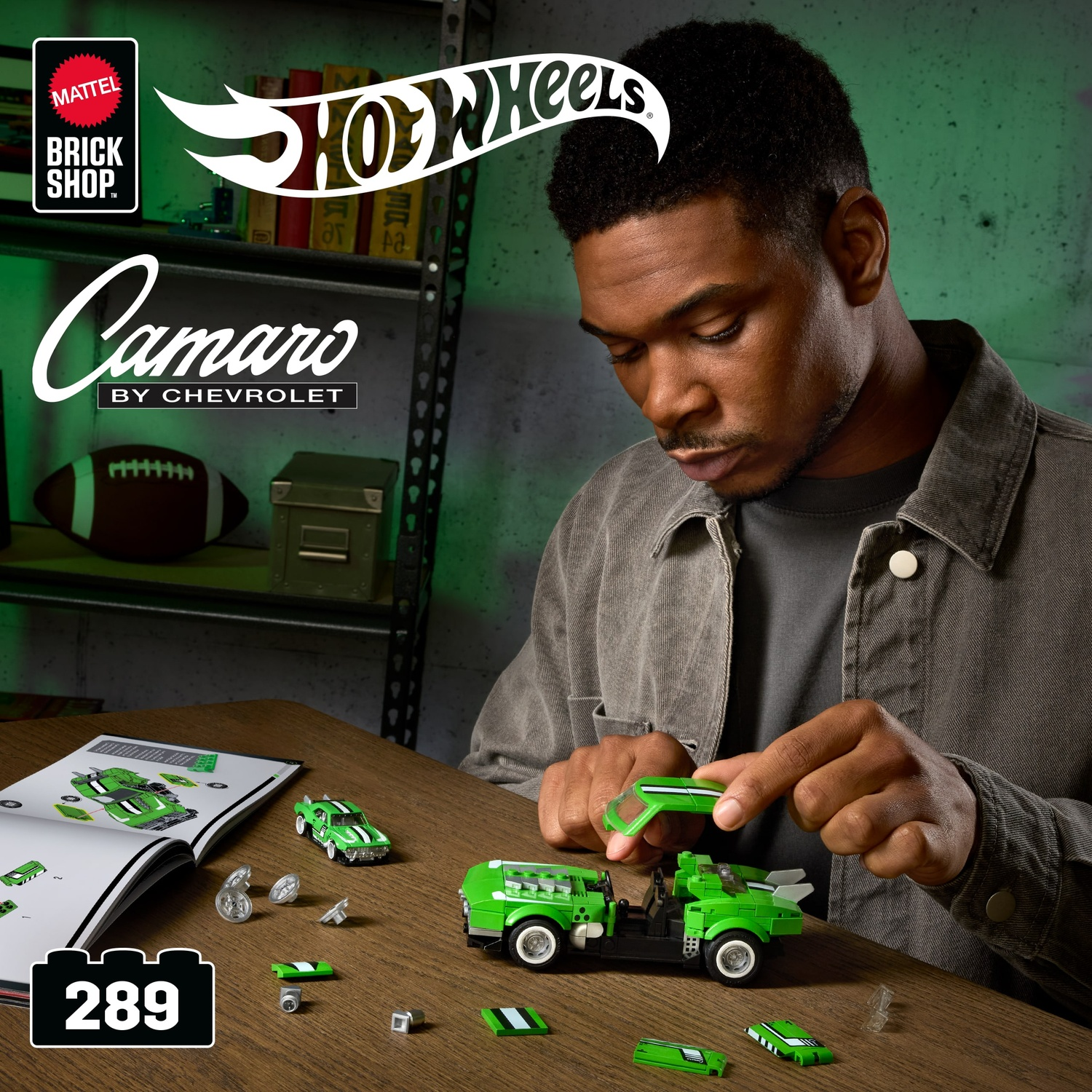 Un uomo sta costruendo un set LEGO Hot Wheels Camaro verde. Un manuale di istruzioni è sul tavolo.