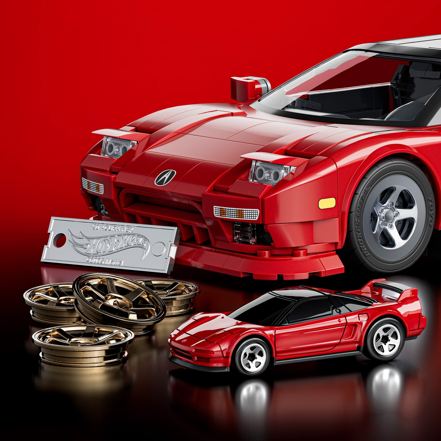 Modellino auto rosso con cerchi argento e una macchina rossa più grande sullo sfondo.