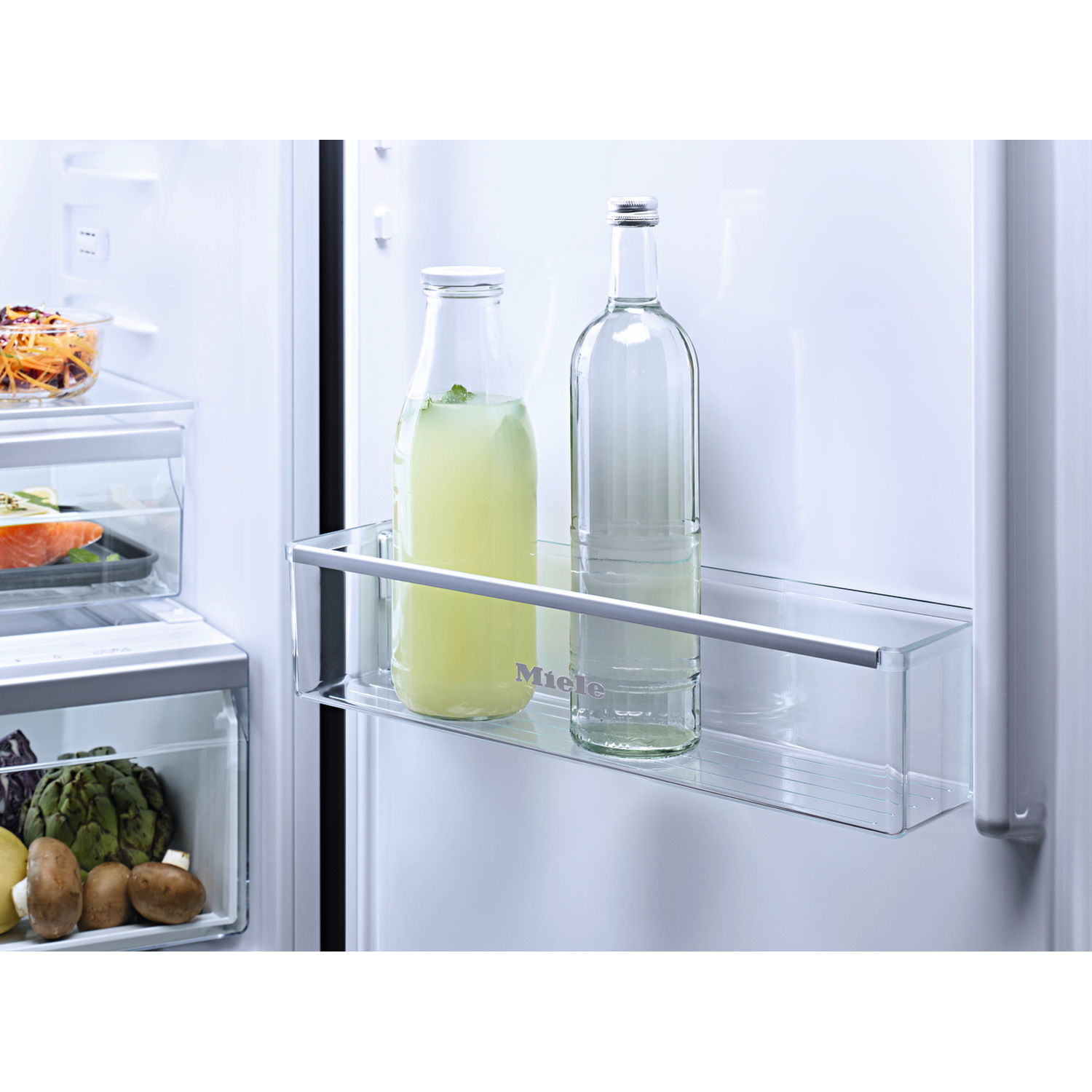 Inside fridge: Bottles with drinks on glass shelf, vegetables in drawer.