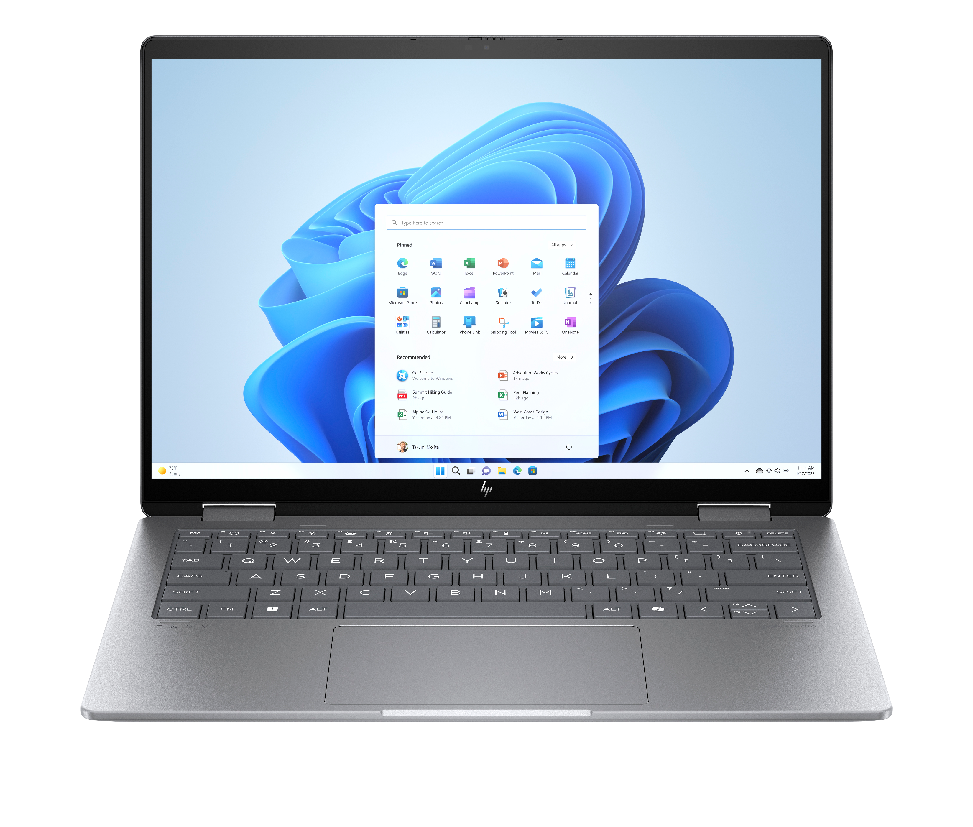 Srebrny laptop z systemem Windows 11 pokazuje ekran startowy, aplikacje i klawiaturę.