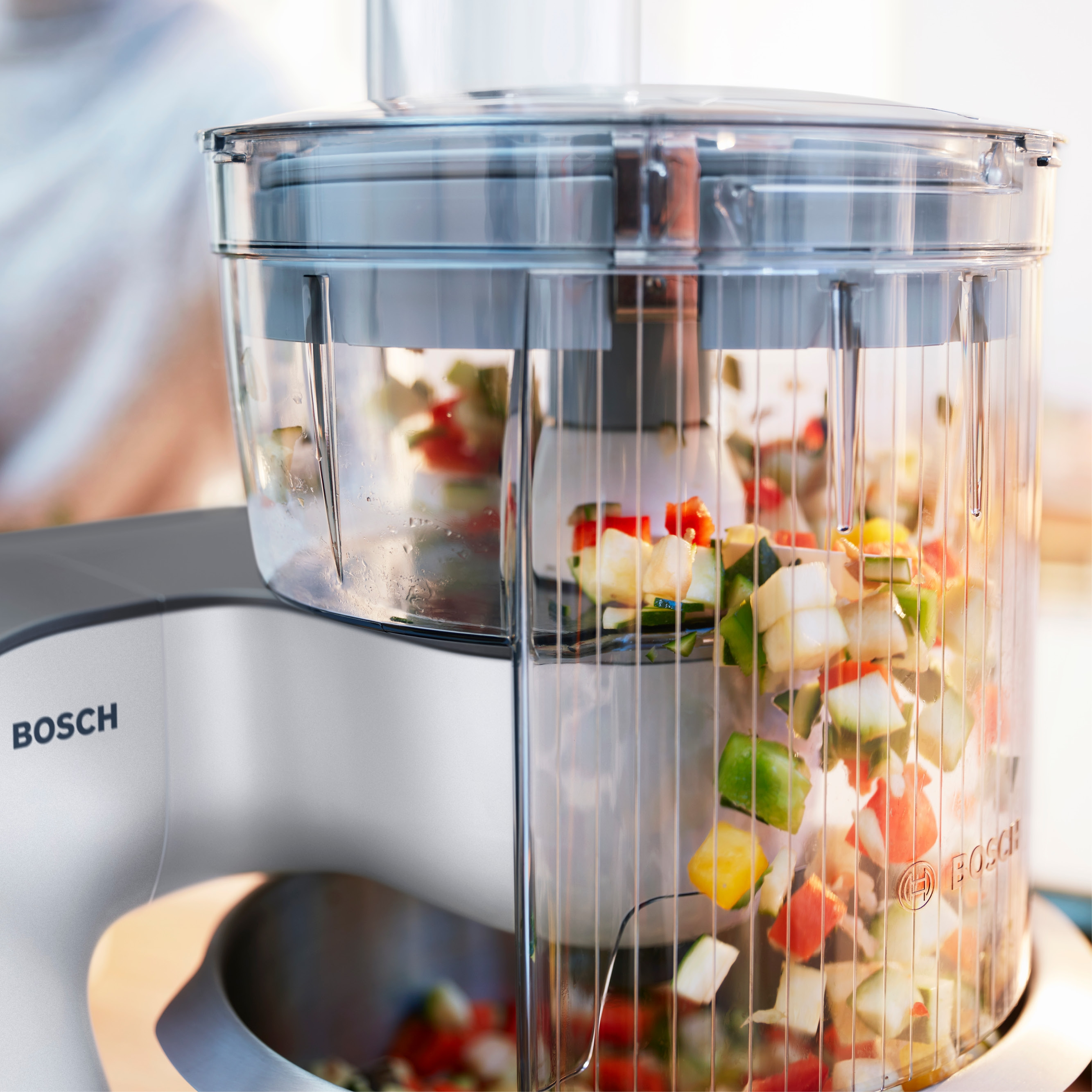 Robot kuchenny Bosch z posiekanymi warzywami: czerwonymi, zielonymi i białymi.