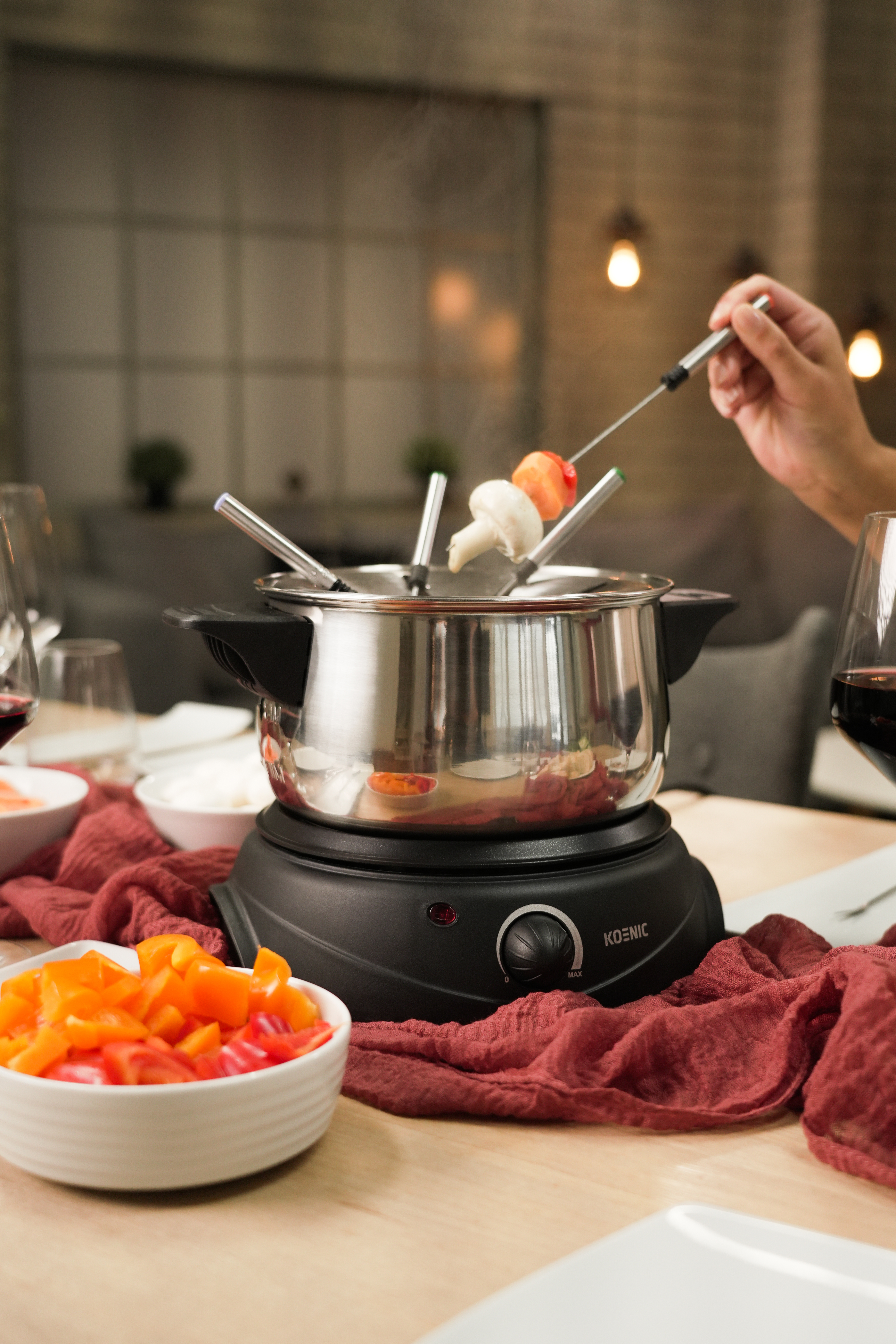 Garnek do fondue z dodatkami i szpadą z grzybami i warzywami.