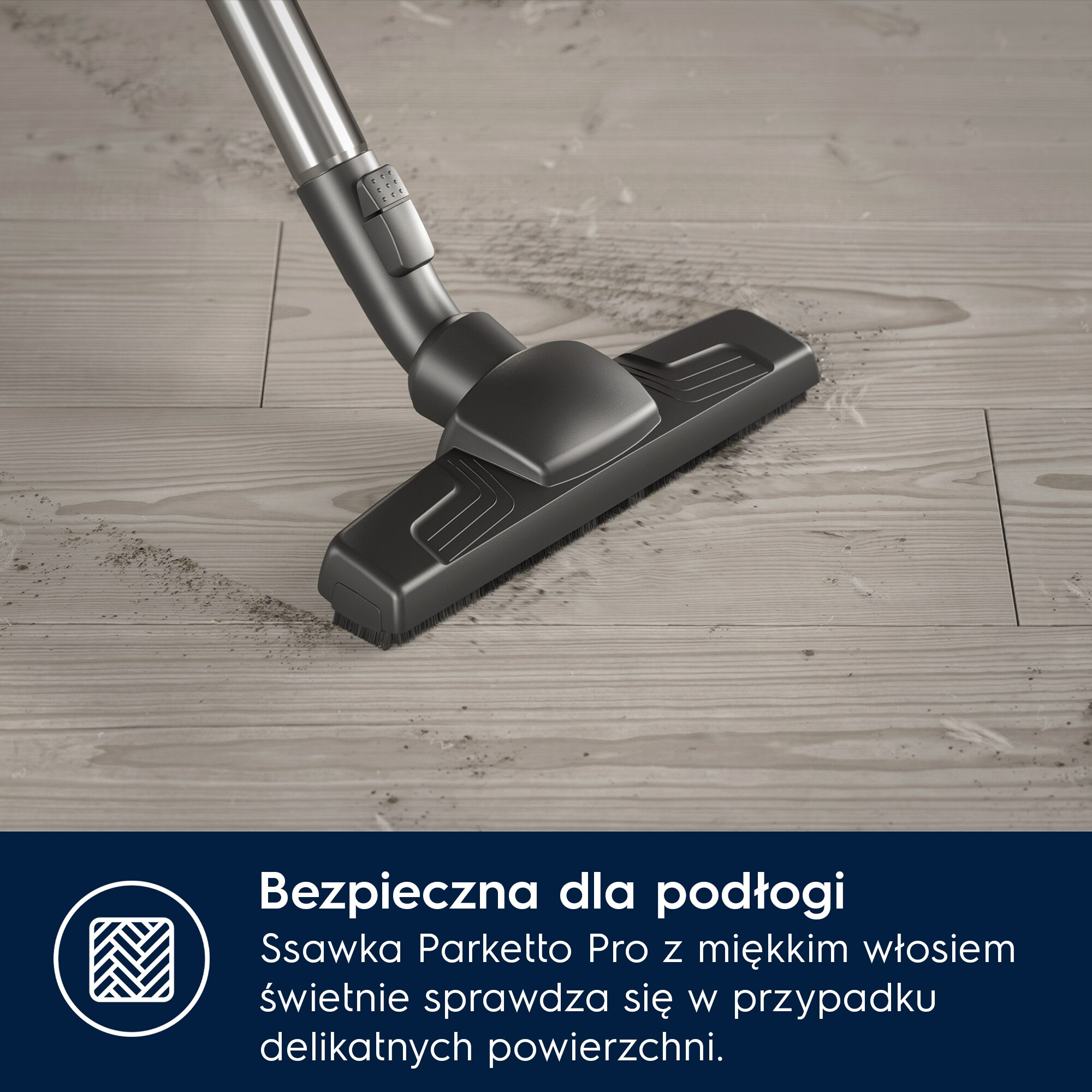 Głowica odkurzacza czyści brud z drewnianej podłogi.